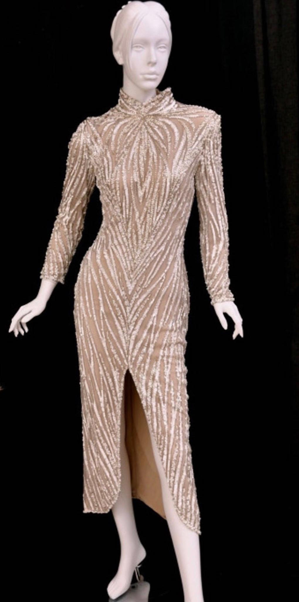 Editor’s note:
1980’s BOB MACKIE Nude Pearl Beaded Gown.
This gown is very similar to the design of the costume worn by RuPaul in Mackie’s book Unmistakable Mackie.
Details: Zip cuffs, front slit
Size 8
Condition: Excellent condition!