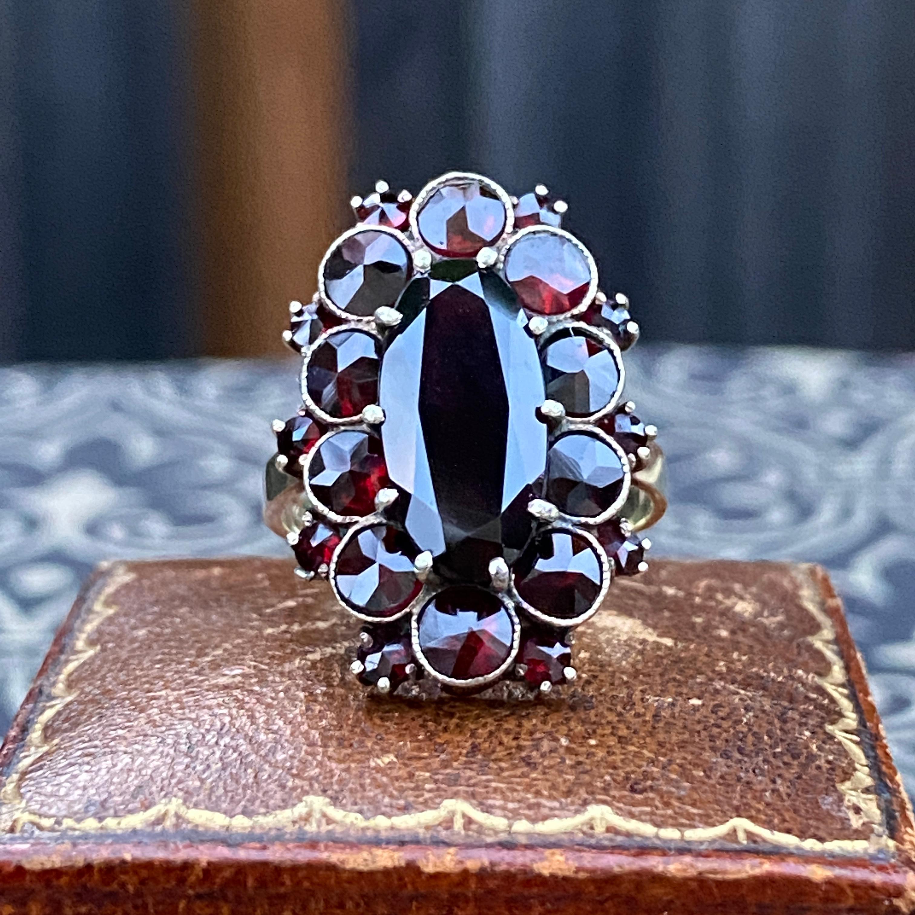 Details: 
Beautiful vintage Bohemian garnet cocktail ring Vermeil silver and 14K gold. The ring has 21 garnets, the large oval center garnet measures 15 x 7.3mm, next there are 10 round garnets measuring 4mm, and 10 additional small garnets