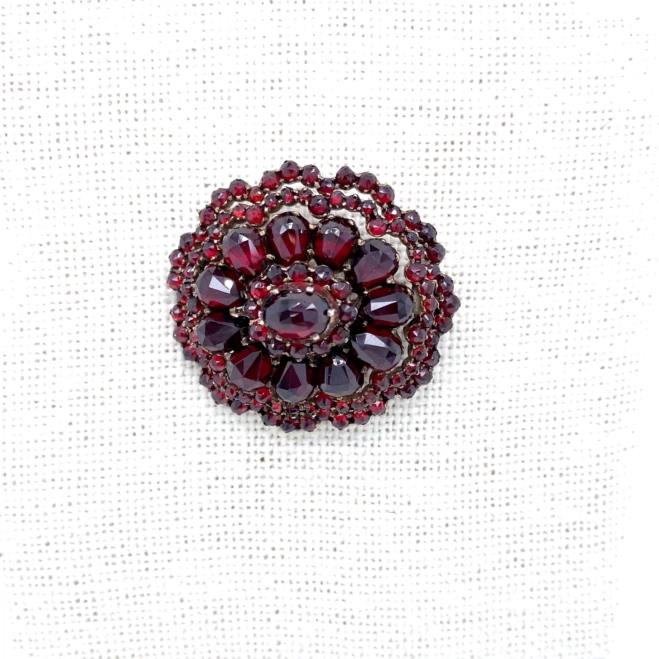 This circa 1990s vermeil Bohemian garnet brooch harkens back to the turn of the 19th century with its dense cluster of Bohemian garnets. The term, Bohemian, first appeared in England around 1848 and represented a free-spirited, artistic, and