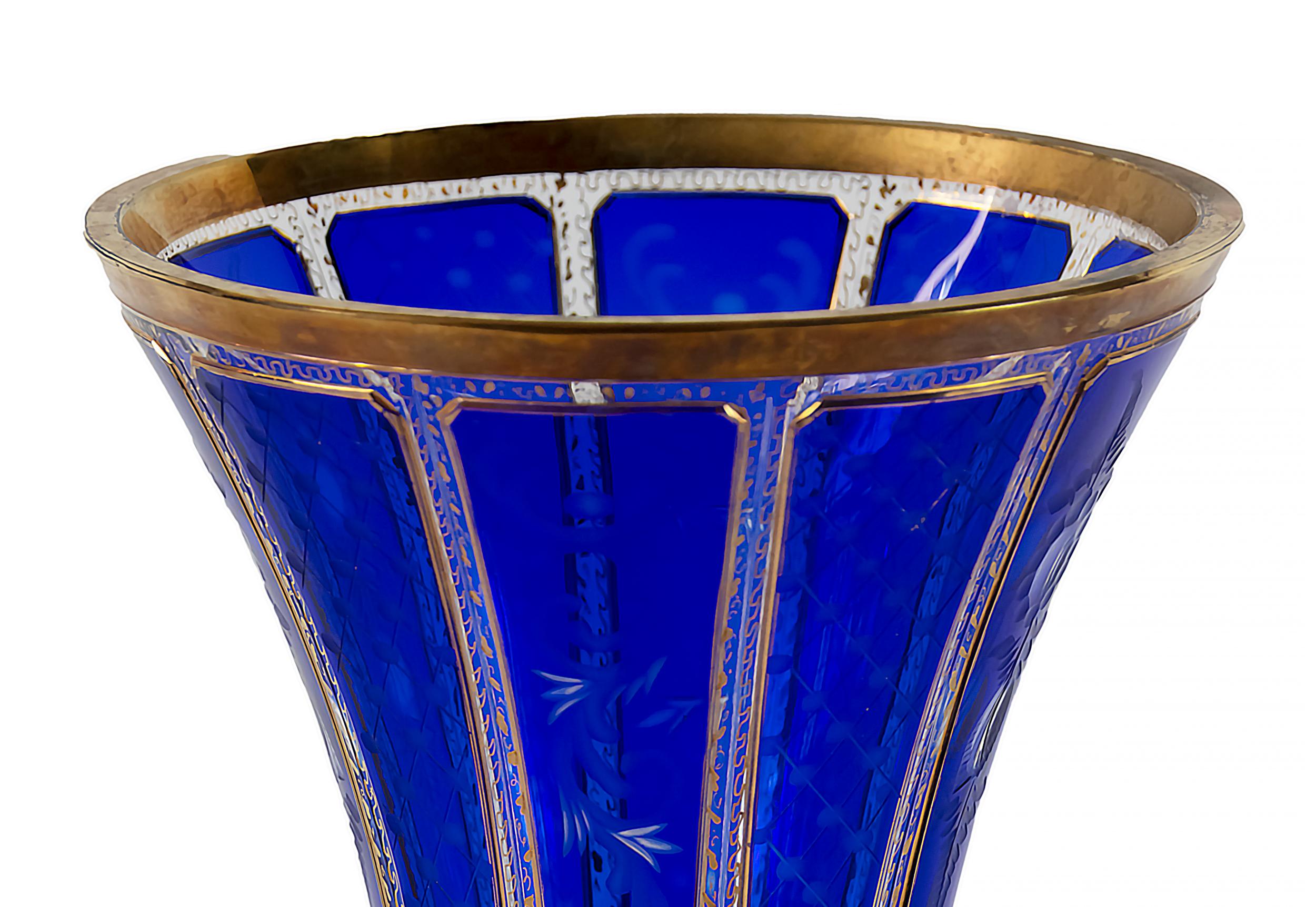 Bohemian transparent glass vase decorated with engraved blue colour glass, gilt trims and gold pattern through the glass.
The vase is heavy and in a very good condition.