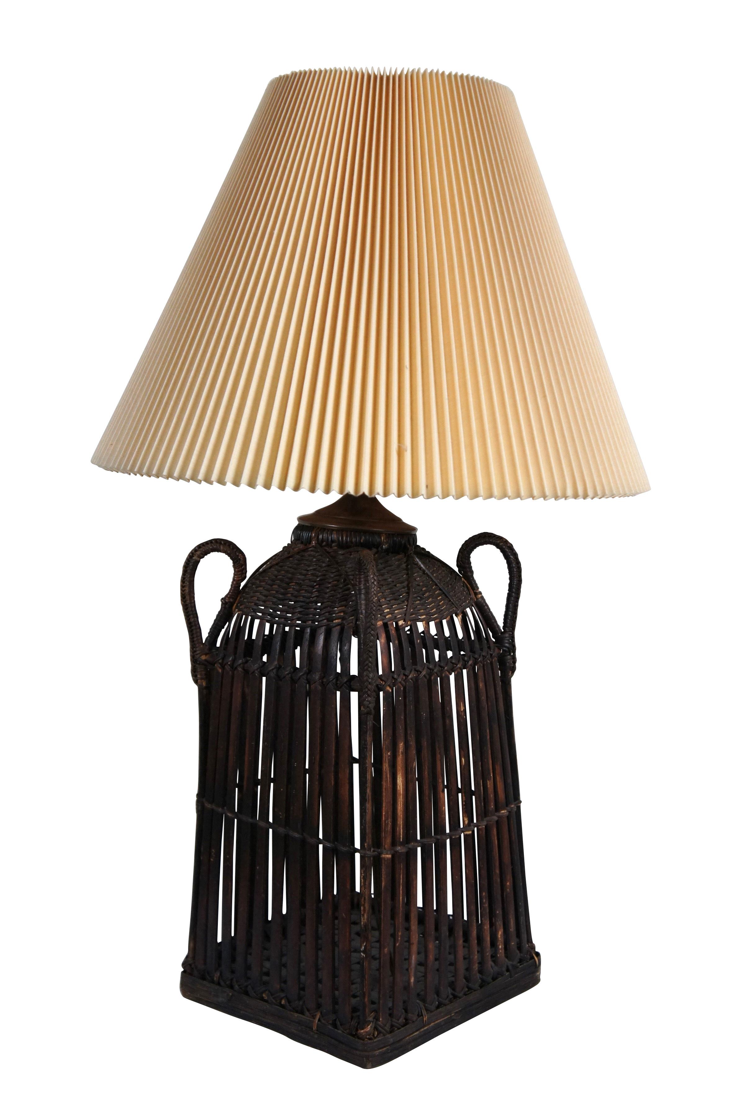 Cesta boho vintage de junco/mimbre convertida en lámpara de mesa. Forma rectangular ahusada con un diseño único que presenta cuatro asas en las esquinas. Incluye arpa, remate de balaustre y pantalla de tela plisada.

Dimensiones:
9