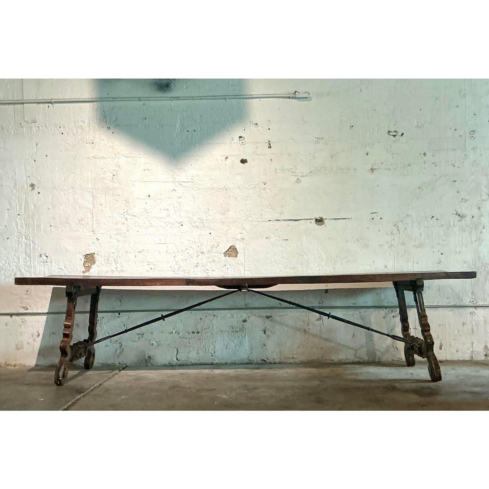 Embodying centuries of rustic European grandeur, this monumental 18th-century style dining table is a singular work of art. Its commanding presence is defined by the dramatically carved, lyre-form trestle legs, hand-hewn from solid, dark-stained