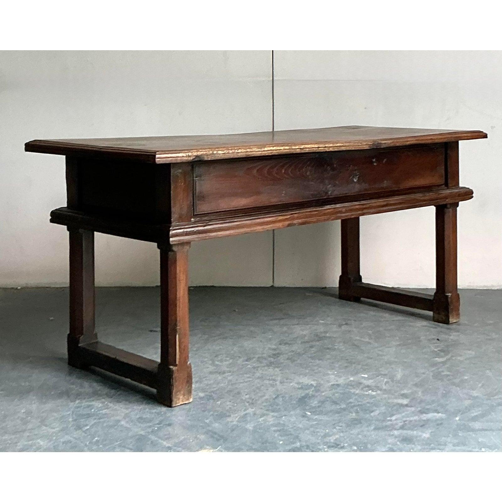 Bring timeless charm to your interiors with this exquisite 18th Century Spanish Writing Desk. Crafted from solid wood with rich patina, this desk showcases classic Old World craftsmanship, featuring clean lines, sturdy trestle-style legs, and two