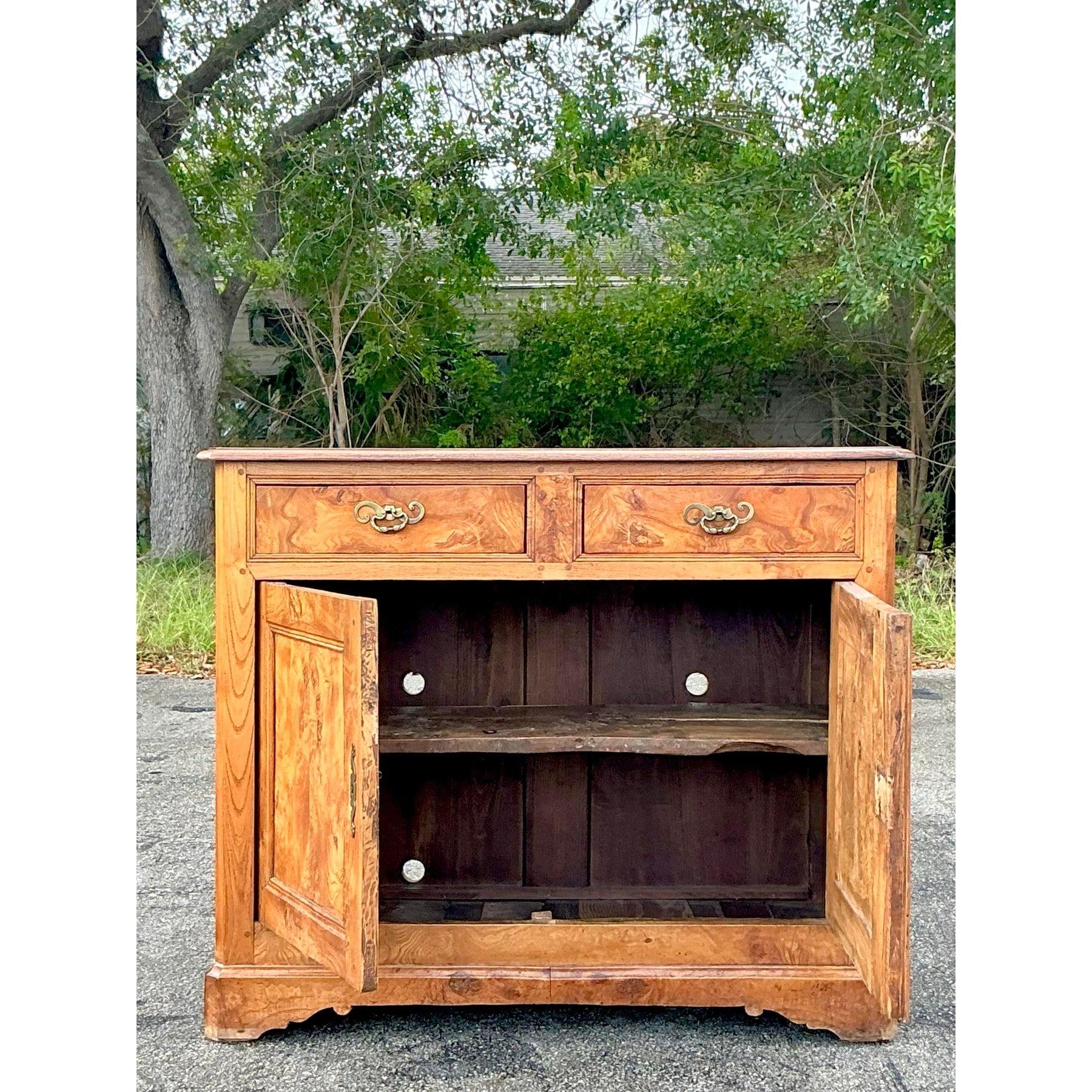 Questa squisita credenza in legno di radica del XIX secolo incarna una maestria senza tempo grazie alle ricche venature del legno, alla patina calda e agli intricati dettagli. Dotato di due cassetti superiori con eleganti tiretti in ottone e di uno