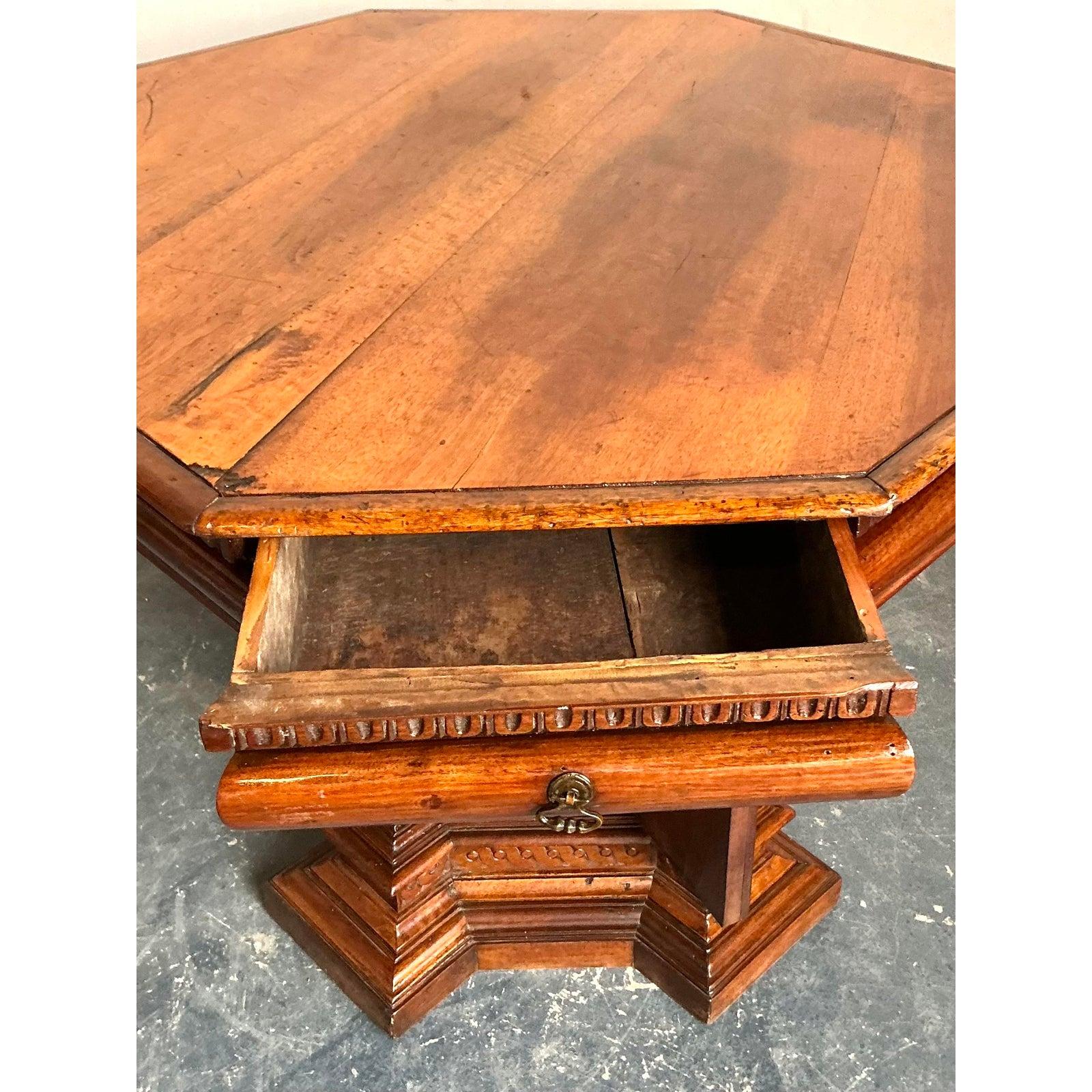 This substantial octagonal pedestal table is a magnificent example of late 19th-century craftsmanship, displaying the complex, dramatic carving typical of the Gothic and Renaissance Revival movements. Crafted from warm, rich wood (likely oak or