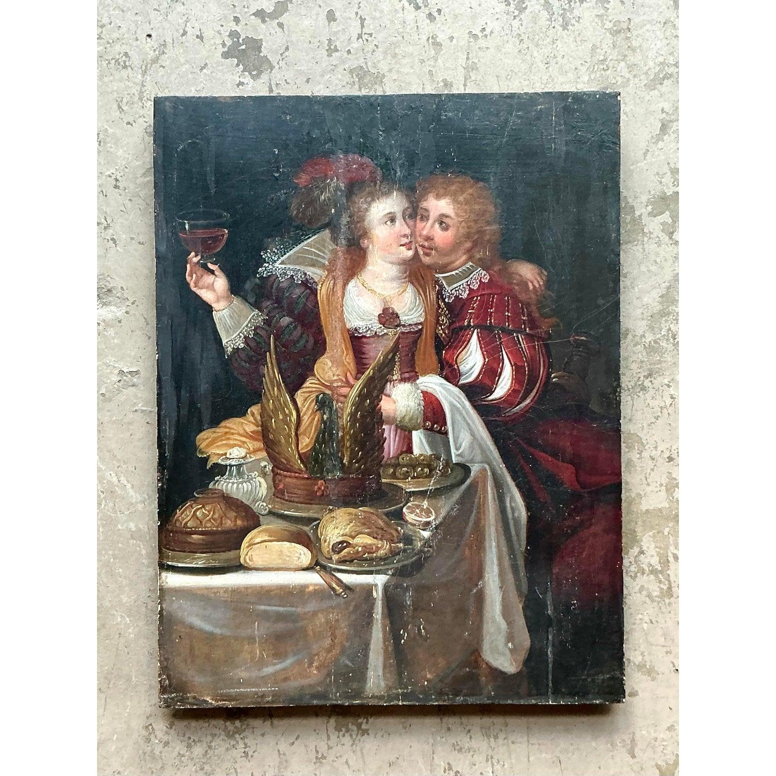 Dieses charmante Ölgemälde auf Karton aus dem 19. Jahrhundert fängt eine romantische und intime Szene ein, die einen ausgeprägten böhmischen Charme versprüht. Das Kunstwerk zeigt ein reich gekleidetes Paar an einem mit Speisen und Getränken
