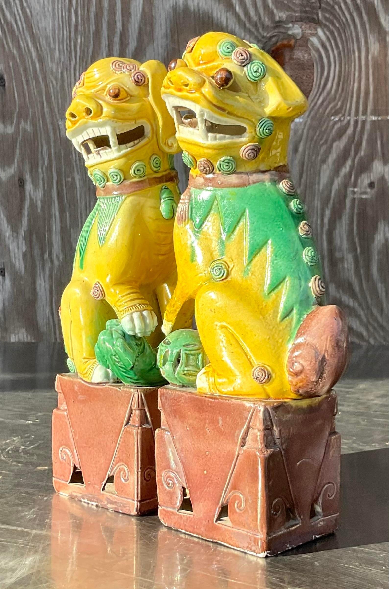 A fabulous pair of vintage Boho foo dogs. A chic glazed ceramic in a signature 19th Century gold color. Acquired from a Palm Beach estate.