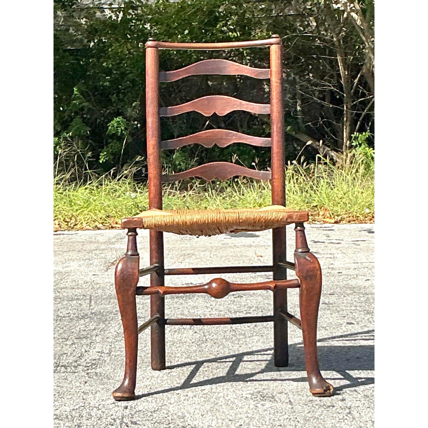 Questa squisita sedia a scaletta del XIX secolo emana un fascino rustico grazie alla sua struttura in legno elegantemente curvata e alla seduta in giunco intrecciato. Realizzato con una maestria classica, la sua splendida patina invecchiata e le