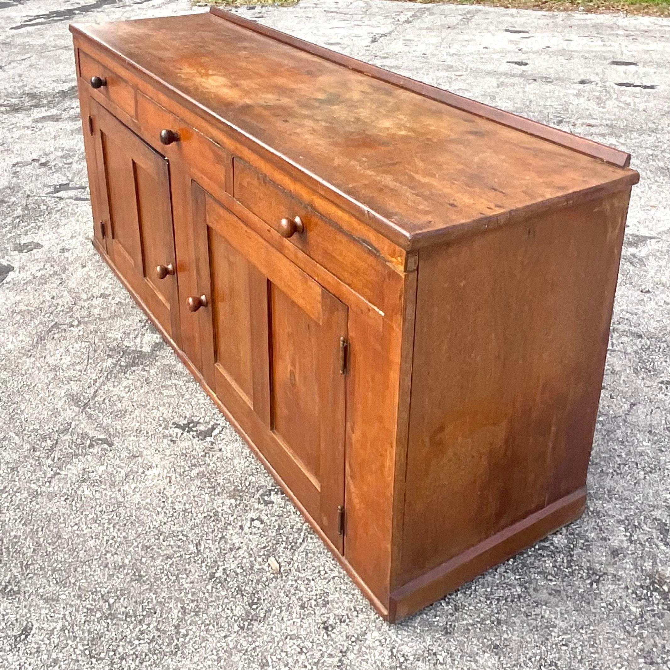 A striking vintage Coastal Primitive credenza. A classic credenza design with an incredible patina from time. Lots of great storage below. Acquired from a Palm Beach estate.