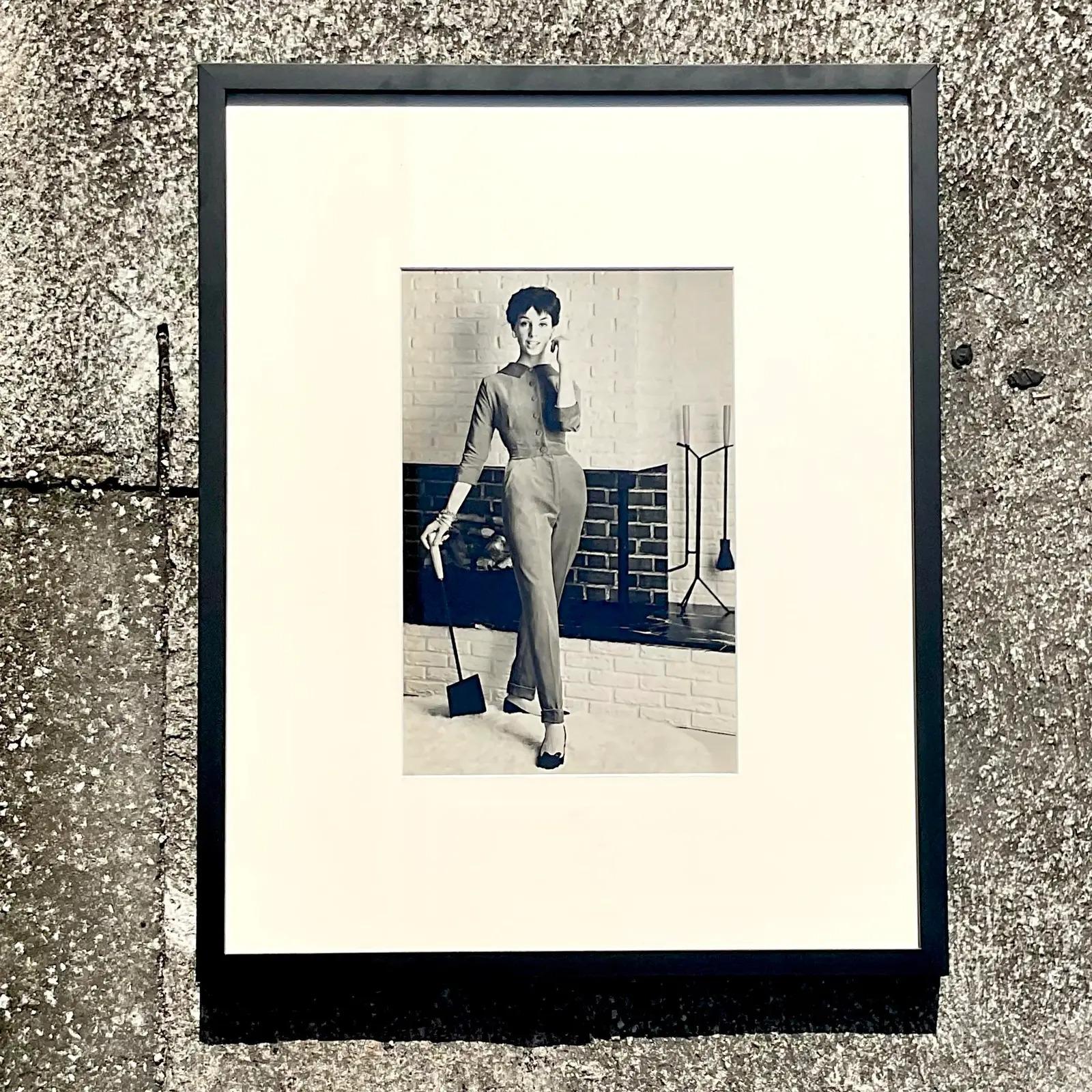Une fantastique photo vintage encadrée en noir et blanc. Une photo de mode chic des années 70 d'une jeune fille avec son balai de cheminée. Rien n'est plus tendance qu'un bon balai de cheminée. Nouvellement encadrée dans un cadre noir chic et