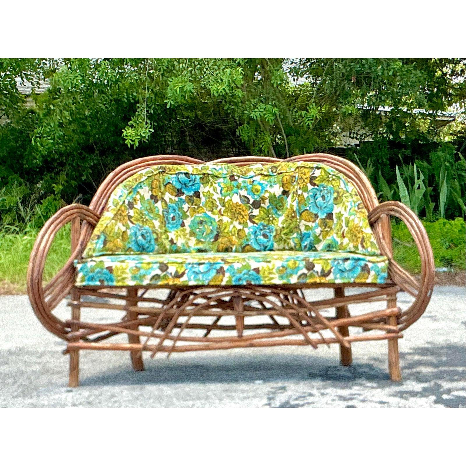 Capture the essence of rustic artistry with this extraordinary vintage Adirondack twig sofa. Masterfully handcrafted from steam-bent twigs, its design features dramatic, looping arms that flow seamlessly into the back and seat, creating a stunning
