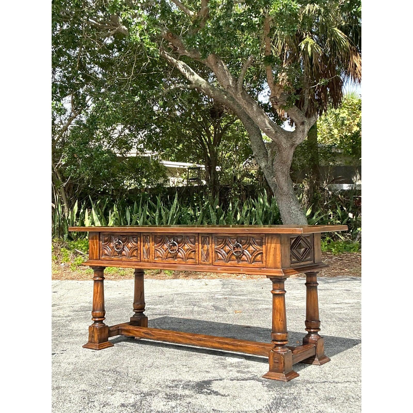 Peppen Sie Ihren Raum auf mit diesem auffälligen, geschnitzten Vintage-Tisch von Alphonso Marina, einem berühmten Namen, der für exquisite Handwerkskunst und zeitloses Design bekannt ist. Mit einer tief geschnitzten Schürze mit gotisch inspirierten