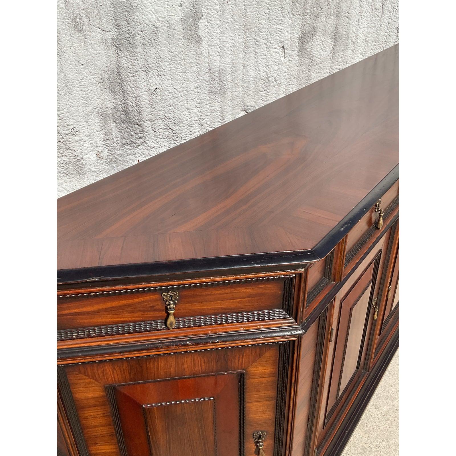 Make a bold statement with this exquisite vintage paneled credenza by Alphonso Marina, a designer known for his rich materials and artisan finishes. This grand piece features stunning fluted trim, intricate inlaid paneling, and lion’s head pulls
