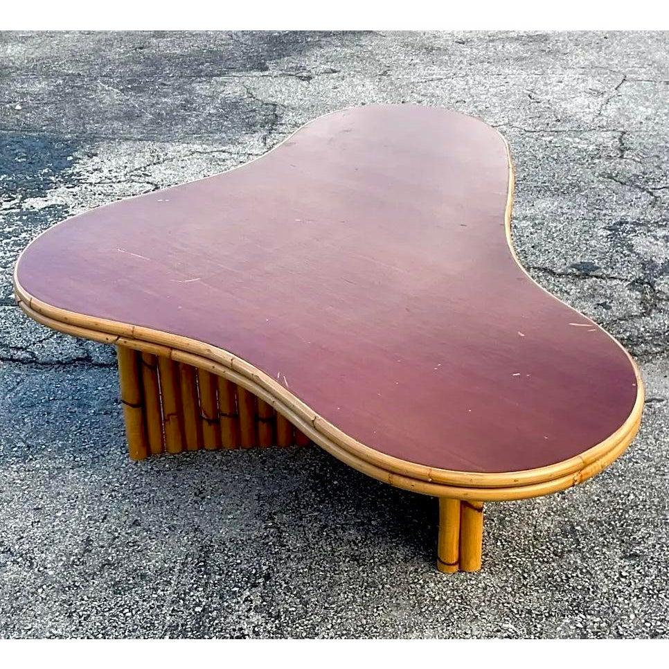 Channel the iconic style of tropical modernism with this stunning vintage biomorphic coffee table. Heavily influenced by the legendary designs of Paul Frankl, this piece features a sensuous, free-form 