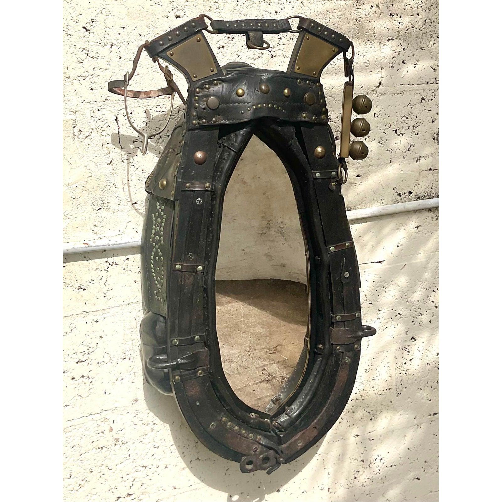 Un fabuleux harnais de cheval ancien qui a été transformé en miroir. Ils sont utilisés pour les chevaux de traîneau ou les chevaux de trait. Magnifique cuir vieilli avec de fantastiques détails de rivets. Les cloches et les étriers ajoutent au