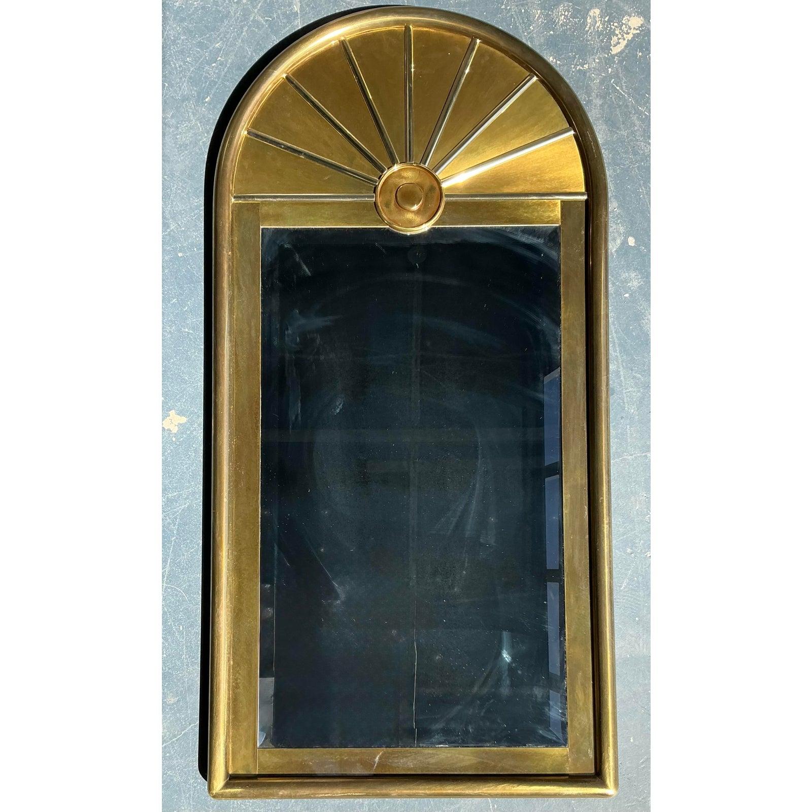 Ce spectaculaire miroir vintage est un exemple typique du glamour de l'époque Hollywood Regency, probablement inspiré par les designs de fabricants emblématiques tels que Mastercraft ou Sarreid Ltd. Le miroir présente un haut corps rectangulaire