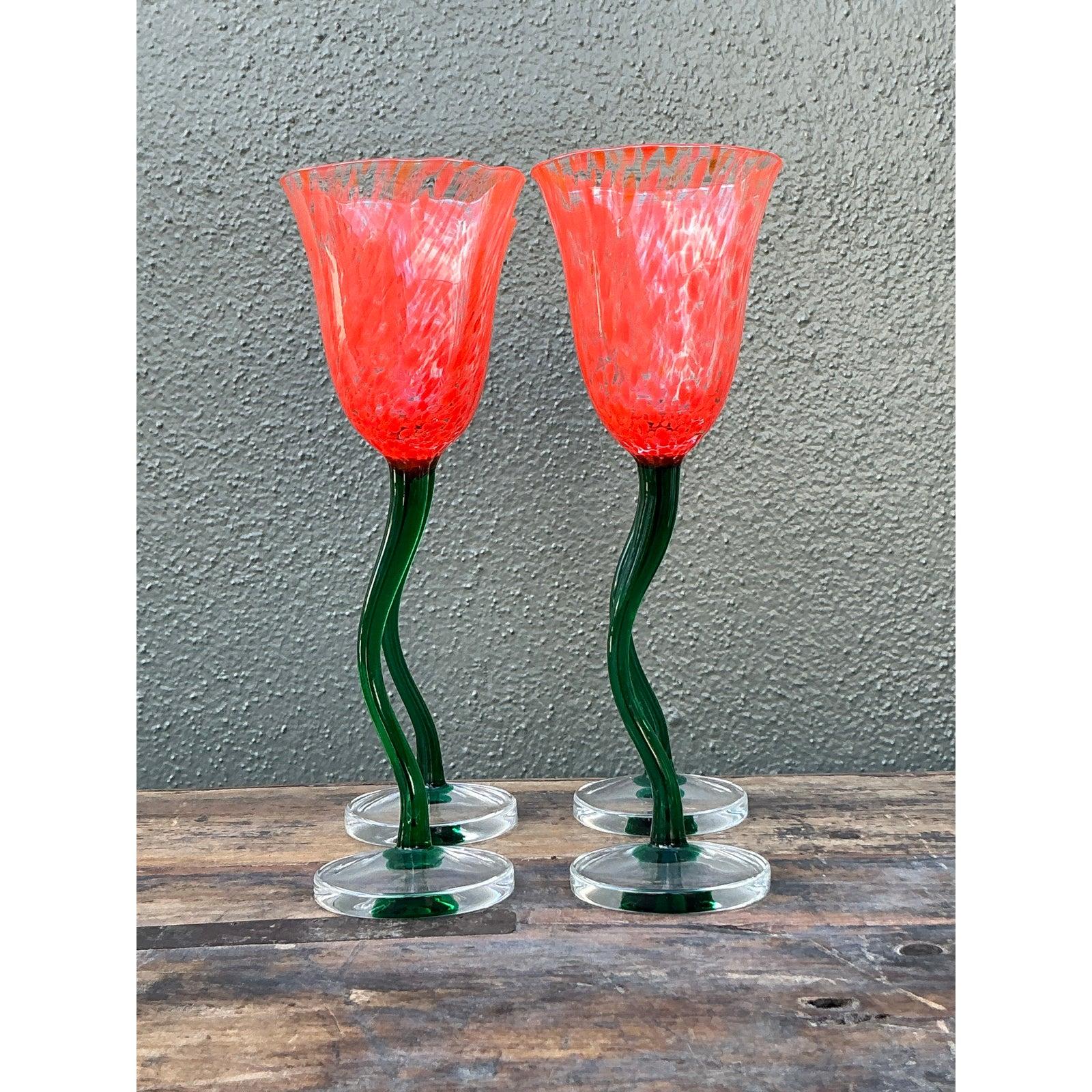 Bring a touch of whimsical garden magic to your table with this enchanting set of four vintage art glass goblets. These handcrafted vessels are designed to resemble blooming tulips or poppies, featuring a vibrant coral-red bowl with a mottled,