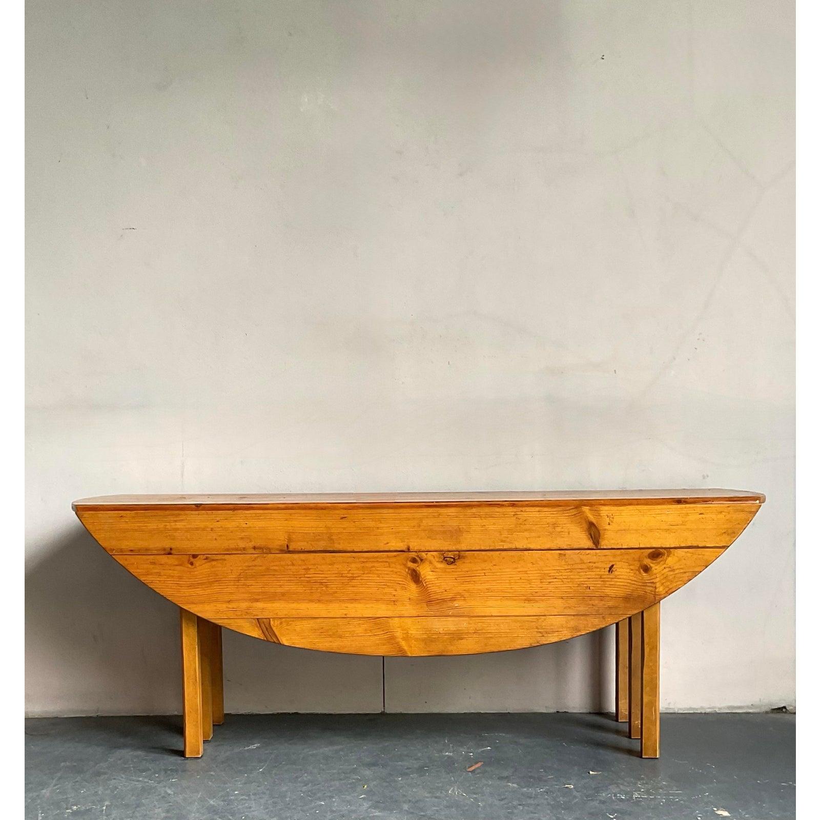 Discover the versatile charm of this vintage Baker Milling Road drop-leaf table, a perfect blend of bohemian spirit and classic craftsmanship. Designed with functionality and style in mind, this table features a robust wooden construction and a