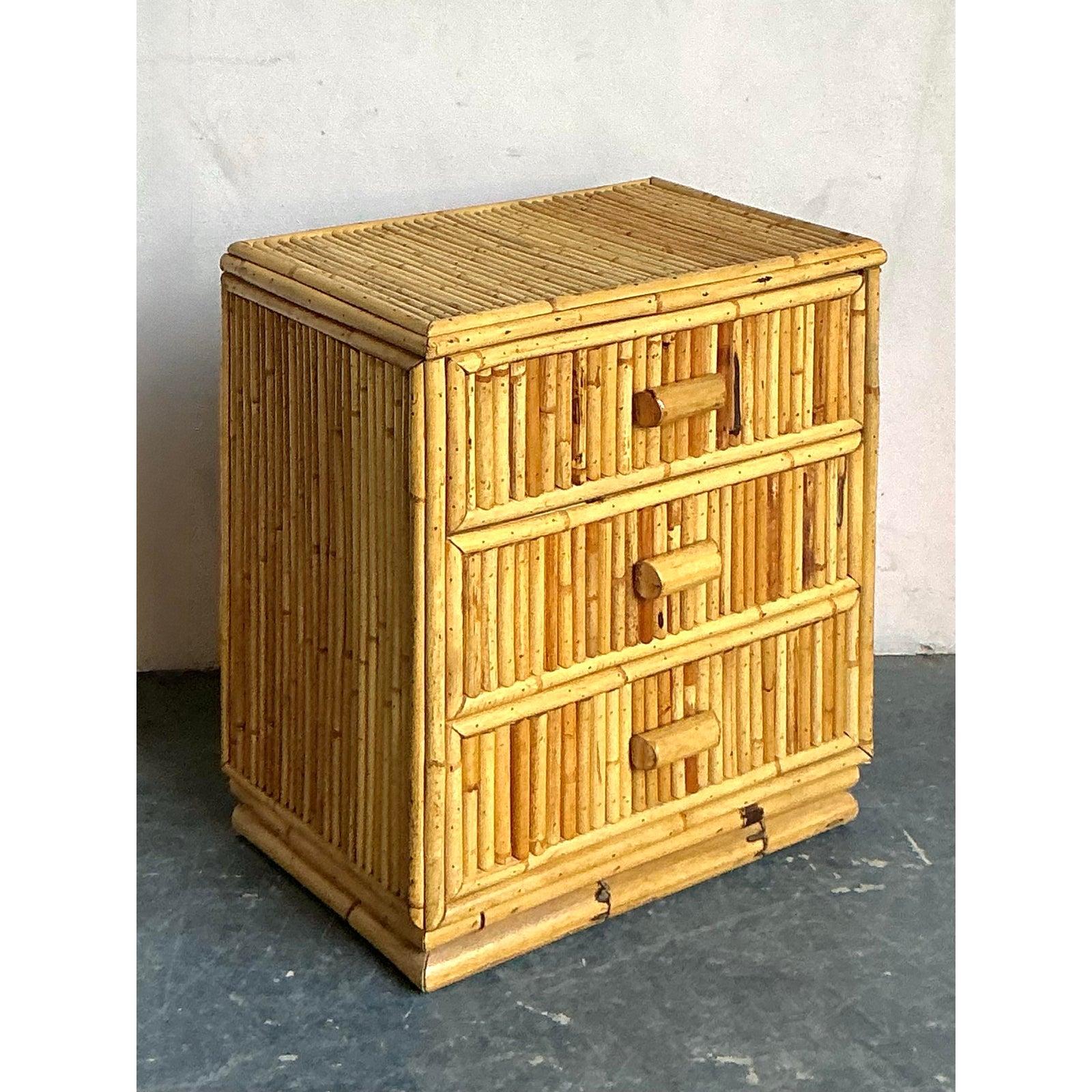 Questa incantevole cassapanca mette in mostra la ricchezza testuale e l'eleganza rilassata dei mobili tropicali vintage. Realizzato interamente in bambù naturale e rattan, il pezzo presenta tre cassetti funzionali rivestiti con canne di bambù
