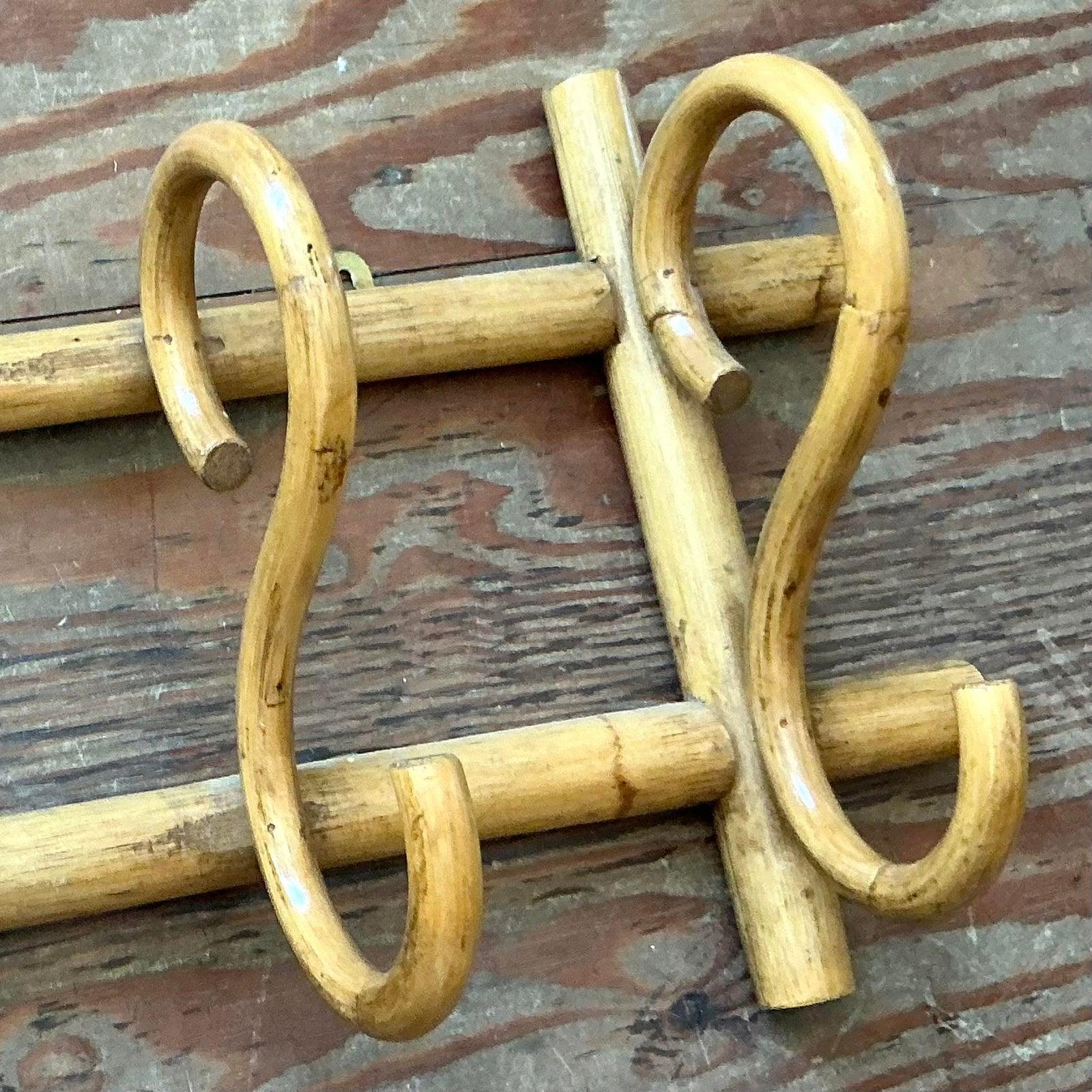Infondi un tocco di charme organico al tuo ingresso o al tuo spazio abitativo con questo delizioso appendiabiti da parete in rattan curvato in stile vintage Boho. Realizzato in rattan naturale sapientemente piegato in curve aggraziate e anse