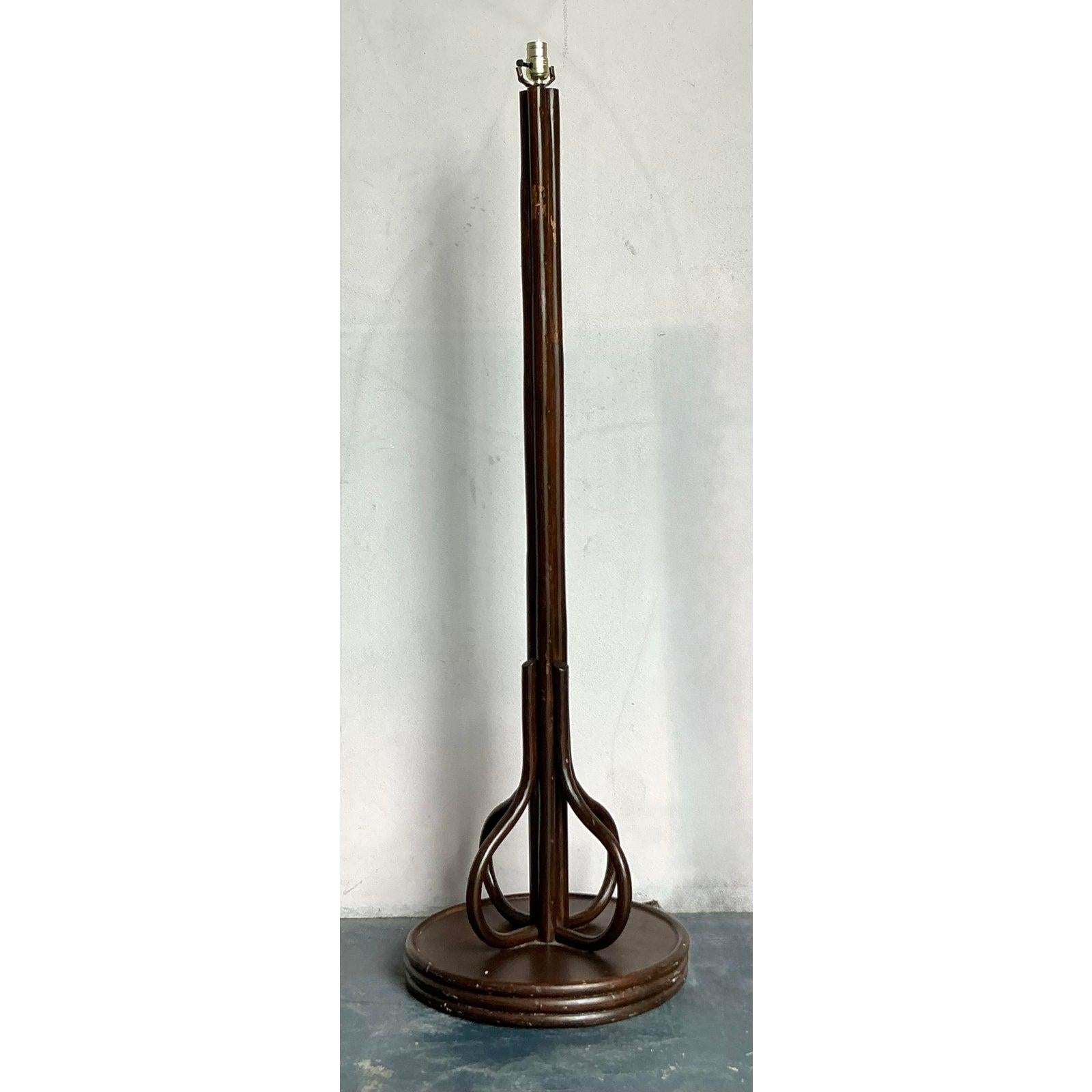 Questa sorprendente lampada da terra mette in mostra le possibilità scultoree del legno curvo e del rattan, incarnando le forme libere e organiche favorite dai movimenti Mid-Century Modern e Boho. La lampada presenta una tinta scura e ricca che
