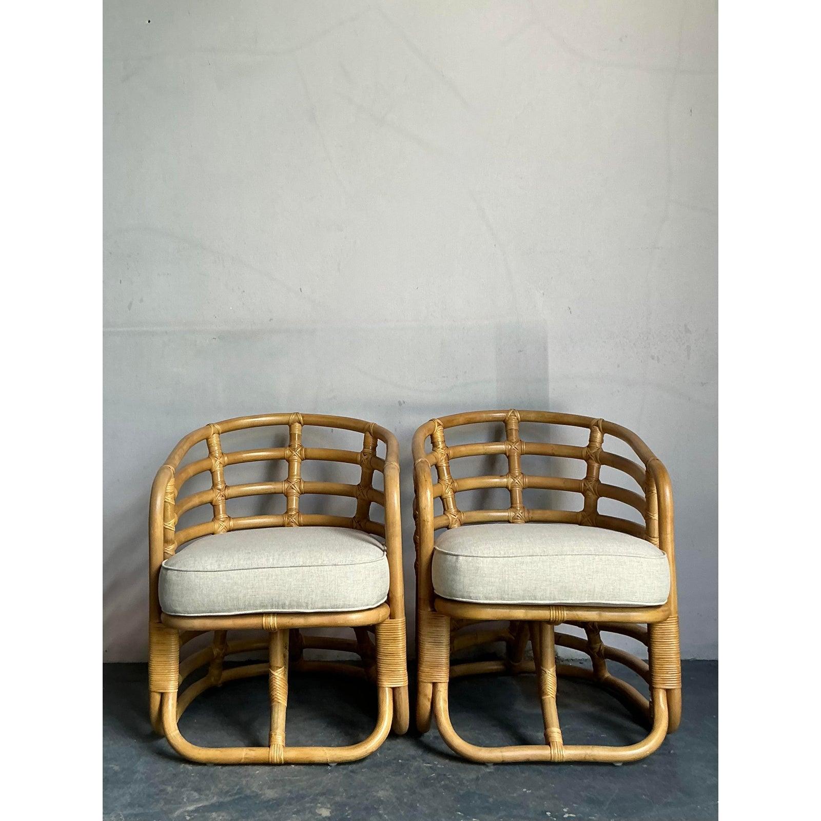 Embrace the essence of relaxed sophistication with this captivating pair of vintage bent rattan lounge chairs. Showcasing exceptional craftsmanship, each chair features a dynamic, sculptural frame constructed from expertly shaped rattan, creating an
