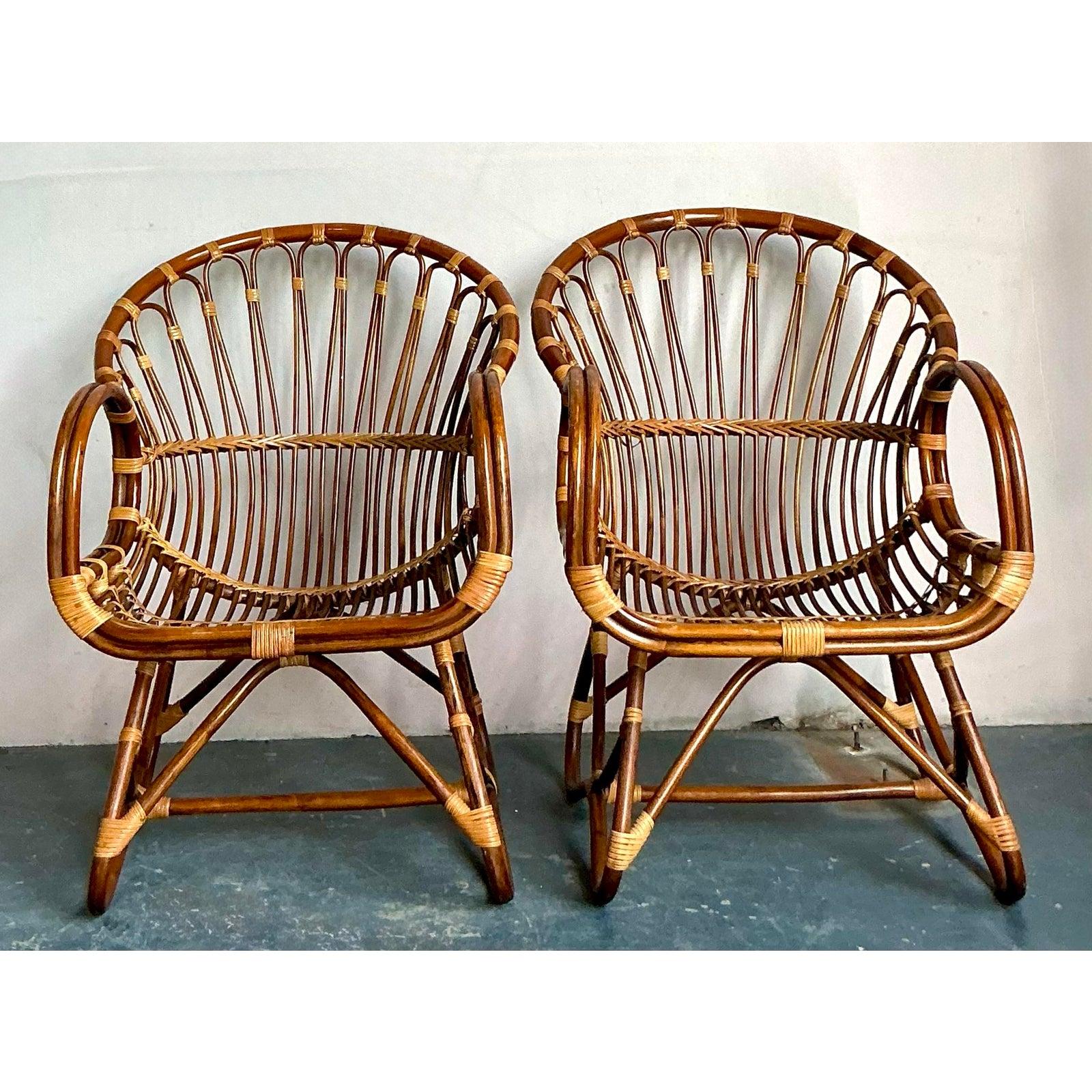 Esta excepcional pareja vintage de tumbonas de ratán capta a la perfección el lujo relajado y orgánico del estilo vacacional de mediados de siglo (a menudo denominado Tiki o Tropical Moderno). Definidas por su escultural armazón de ratán curvado de