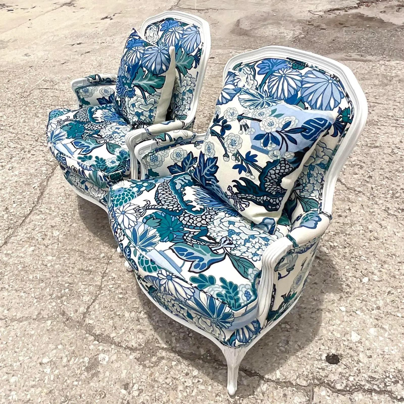 An incredible pair of vintage bergere chairs. A bright white frame with the most gorgeous Brunschwig & Fils dragon print upholstery. Acquired from a legendary Palm Beach family. 