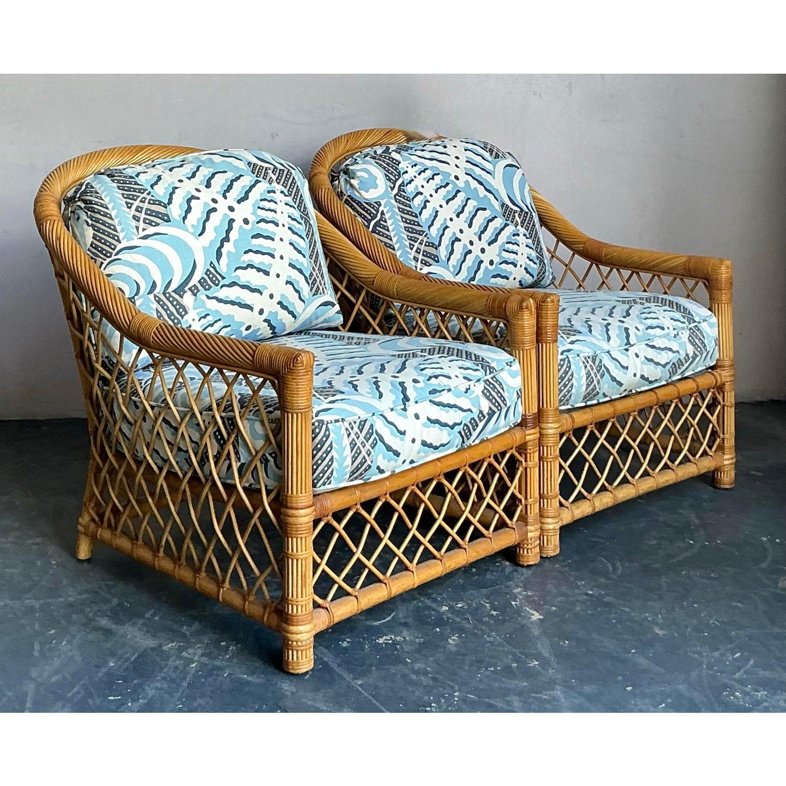Este llamativo par de tumbonas vintage encarna el sofisticado estilo del Hollywood Regency y el diseño costero de los años setenta. Los robustos bastidores están hechos de ratán natural, con elegantes perfiles redondeados y un característico tejido