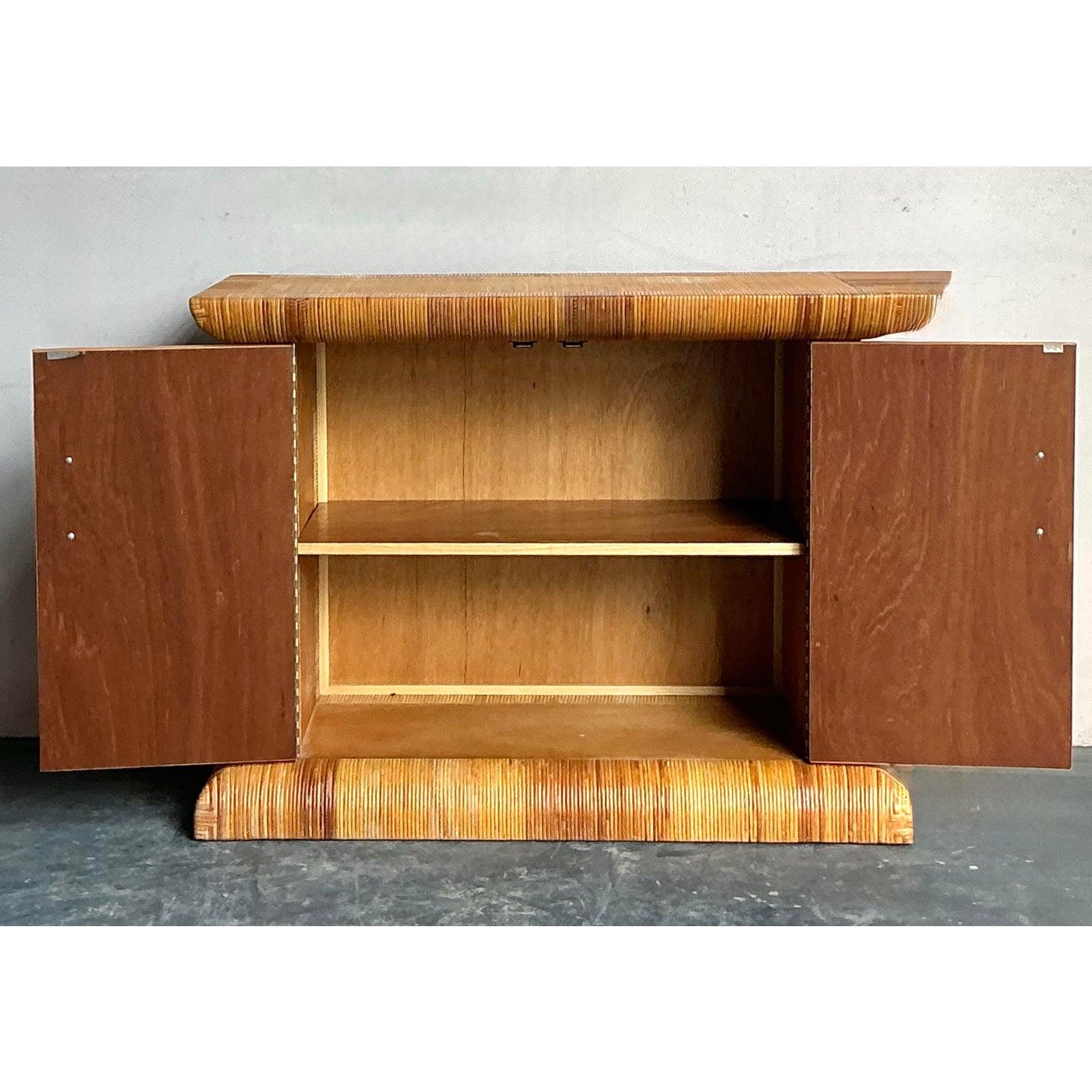 This distinctive cabinet, attributed to the quality craftsmanship of Bielecky Brothers, is a sculptural masterpiece of Mid-Century Coastal design. The piece features a dramatic barrel-shaped plinth base and a corresponding rounded cornice top, both