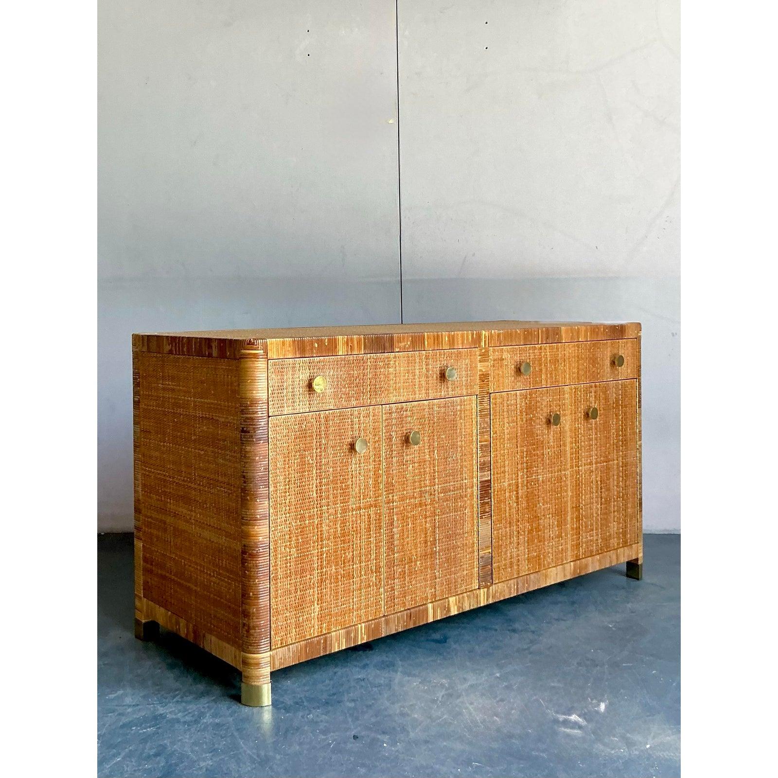 Véritable chef-d'œuvre de design et d'artisanat, cette exquise crédence vintage provient du légendaire fabricant de produits de luxe, Bielecky Brothers. L'ensemble de la pièce est méticuleusement enveloppé de rotin, créant une surface d'une texture