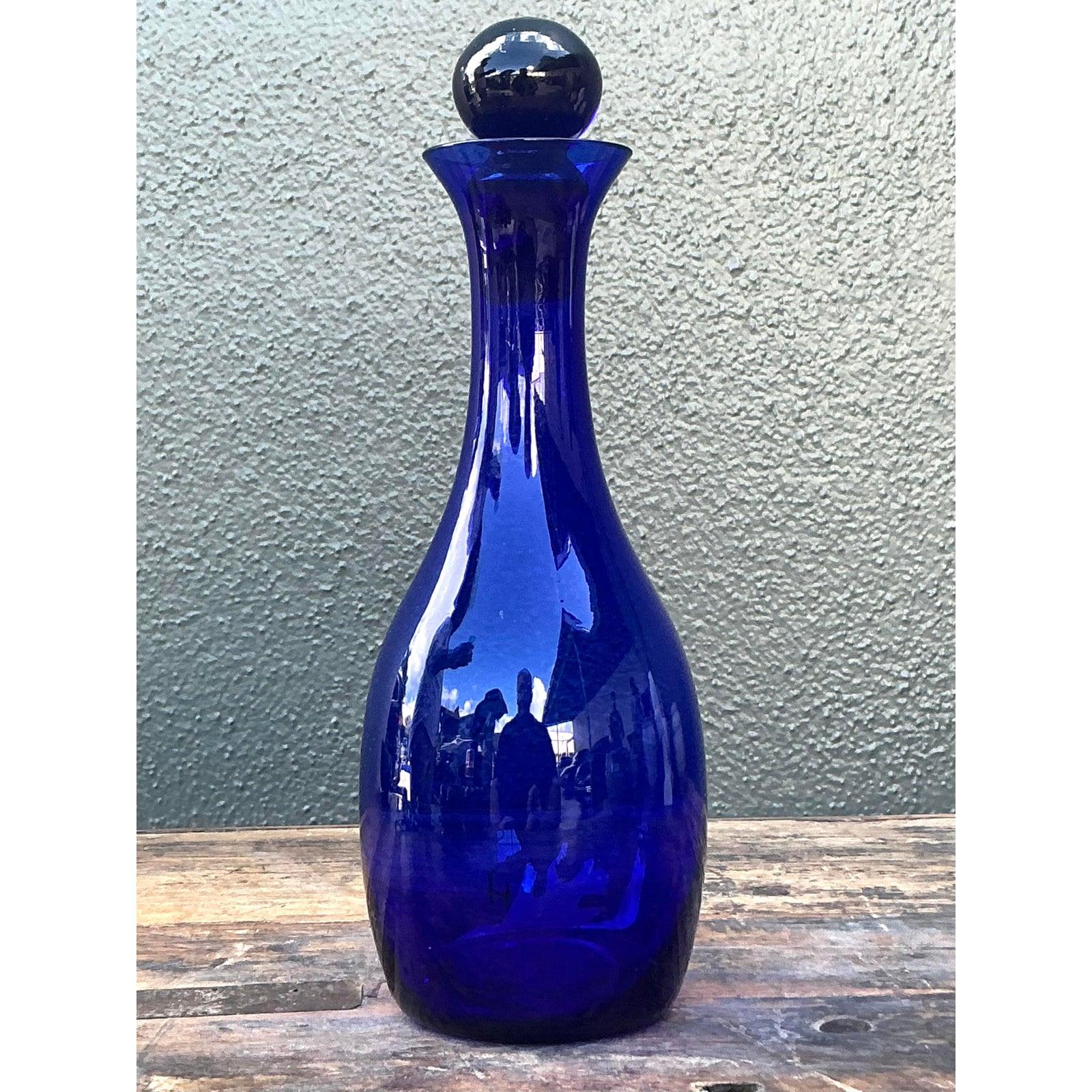 Verleihen Sie Ihren Räumen mit dieser atemberaubenden kobaltblauen Glaskaraffe im Vintage-Stil einen Hauch von satter, satter Farbe. Dieses Gefäß erinnert an die ikonischen Entwürfe von Blenko oder Empoli aus der Mitte des Jahrhunderts und weist