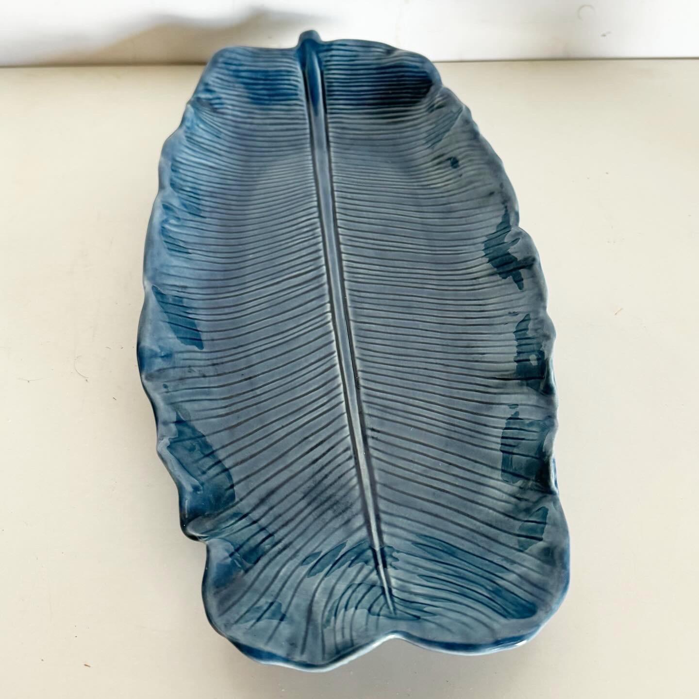 Embrace the vintage charm of the Boho Blue Banana Leaf Platter by Metlox, a vibrant and detailed piece perfect for collectors and bohemian decor enthusiasts alike. This platter showcases Metlox's commitment to quality, featuring a stunning blue