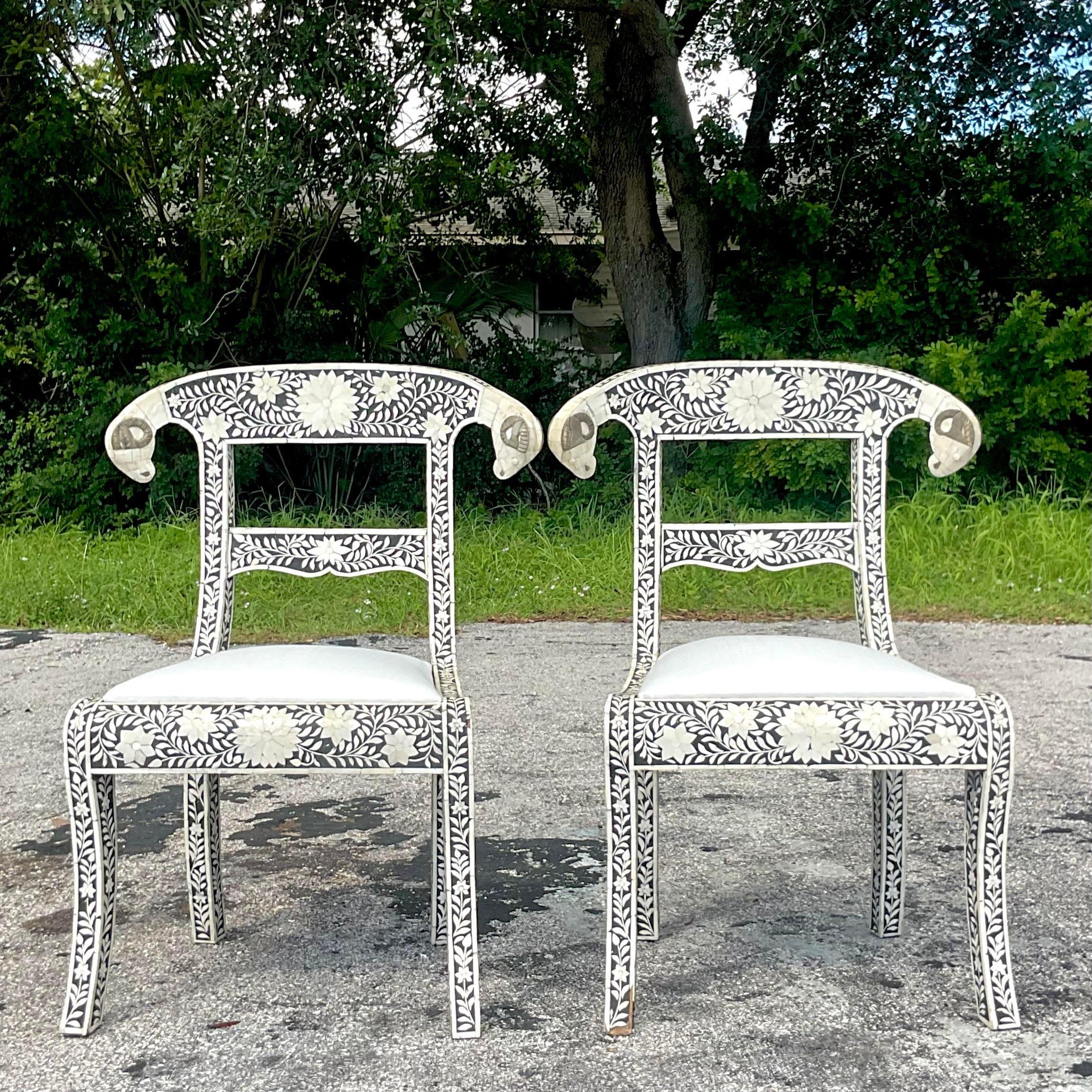 A fabulous pair of vintage Boho dining chairs. Thr famous Wedding chair with Ram’s head detail. Beautiful all over horn inlay in graphic black and cream colors. Acquired from a Palm Beach estate. 
