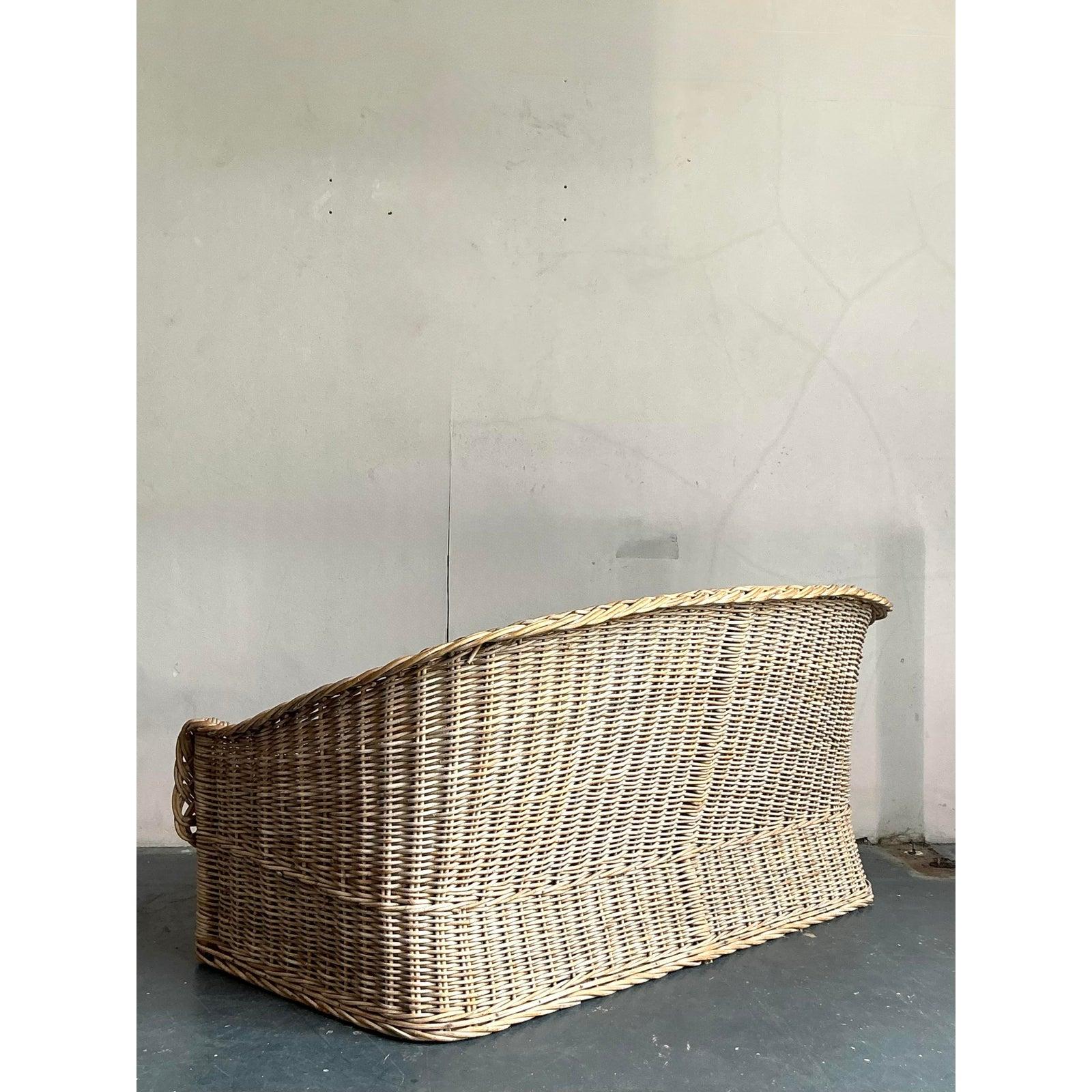 Embrassez l'essence de la sophistication décontractée avec ce charmant canapé vintage en rotin tressé. Magnifique exemple de design artisanal, cette pièce se définit par sa silhouette accueillante, légèrement inclinée, et par les exceptionnels