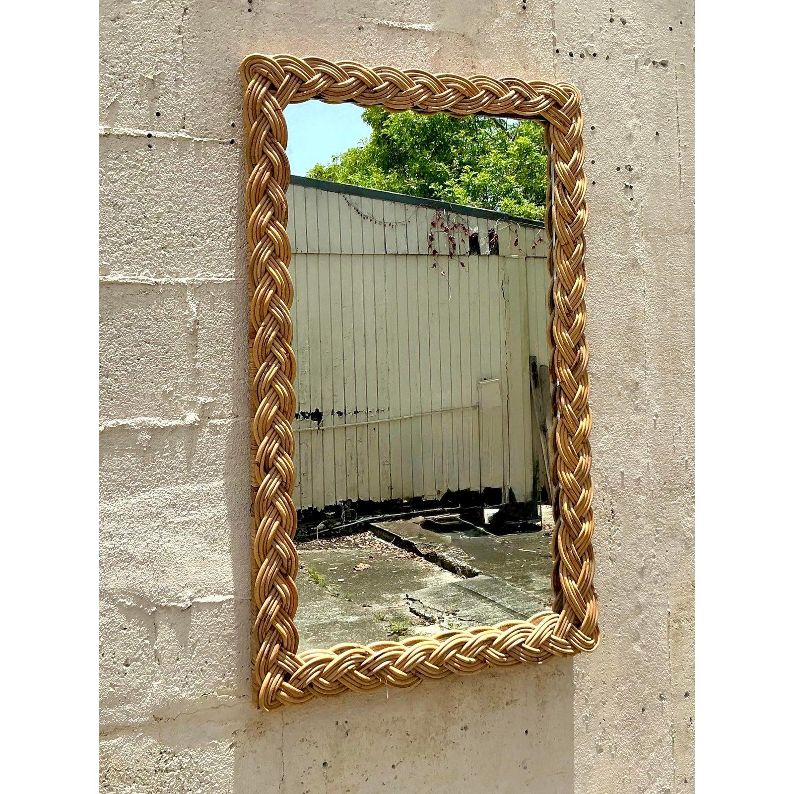 Introduce a touch of organic warmth and effortless style to your walls with this captivating vintage braided rattan mirror. The beautifully handcrafted frame, featuring a substantial, intricately woven braid of natural rattan, showcases exceptional