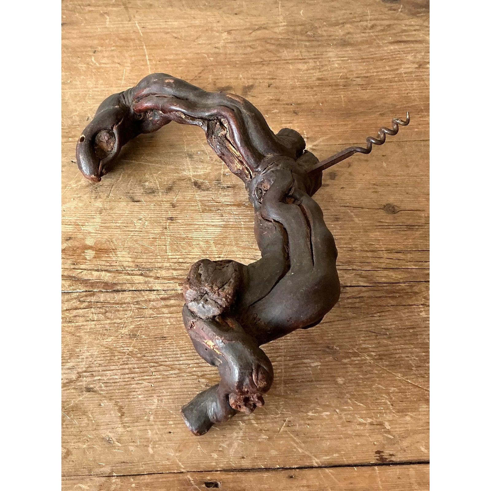 Ce tire-bouchon vintage unique est un merveilleux exemple d'art populaire fonctionnel, célébrant la beauté robuste du bois naturel. La poignée est formée d'un morceau noueux et profondément tordu de vigne ancienne ou d'un bois de racine similaire,