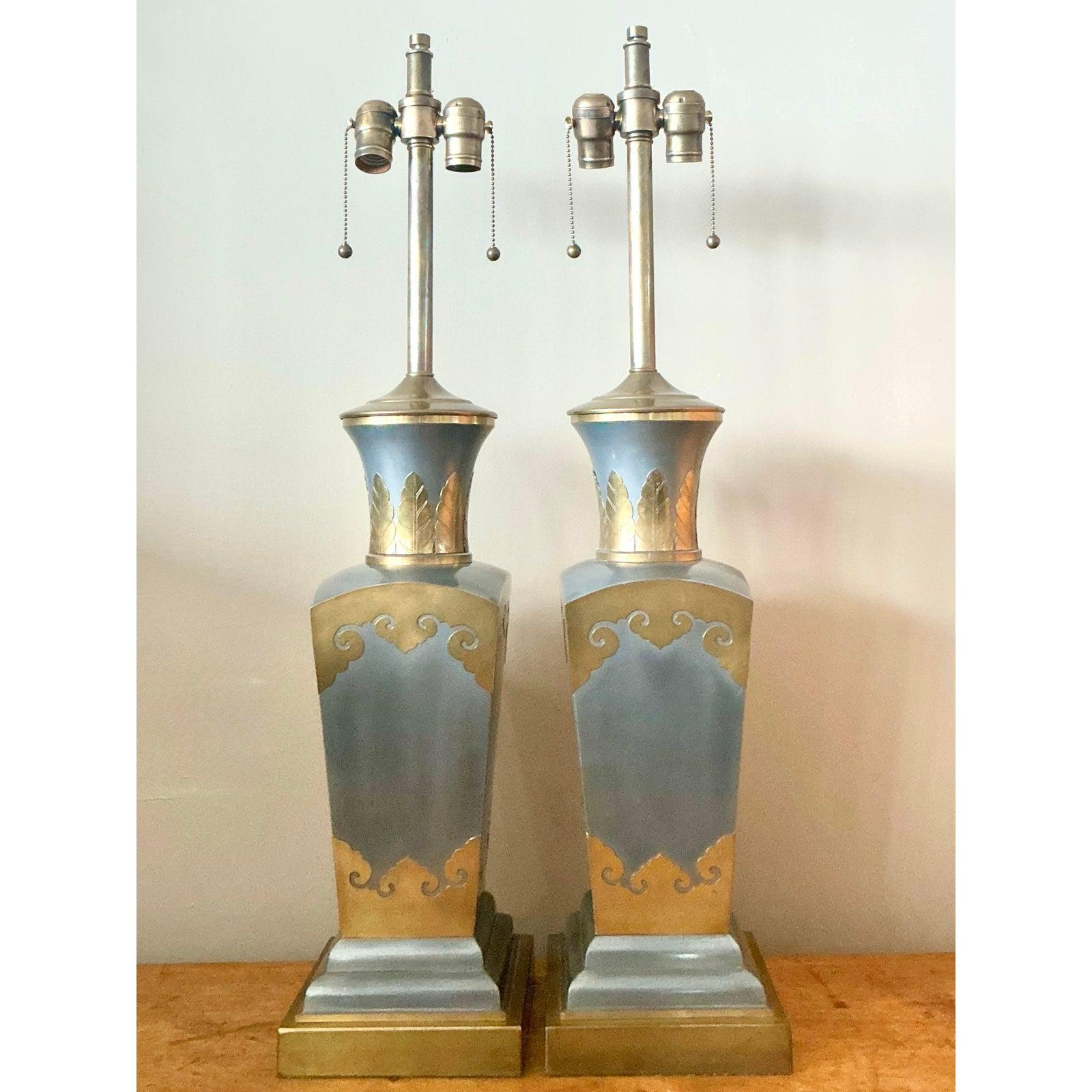 Illuminez votre intérieur avec cette exquise paire de lampes de table vintage Hollywood Regency. Chaque lampe présente un corps majestueux en forme d'urne carrée, mettant en valeur un mélange magistral de matériaux riches et d'art inspiré de la