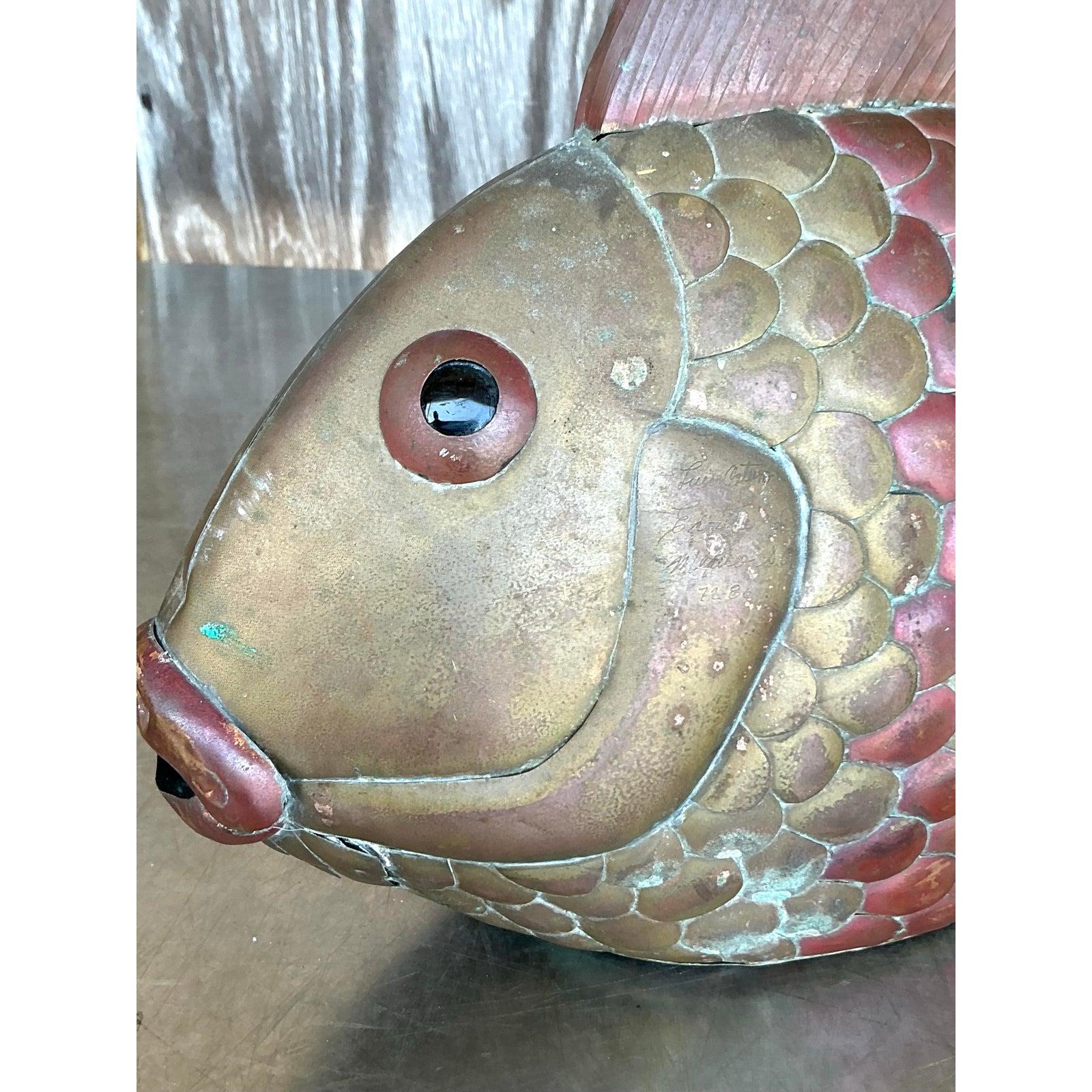 Aggiungi un tocco di arte stravagante al tuo spazio con questa scultura di pesce in ottone vintage, disegnata nello stile distintivo di Sergio Bustamante. Con dettagli modellati a mano e una patina affascinante, questo oggetto decorativo unico fonde
