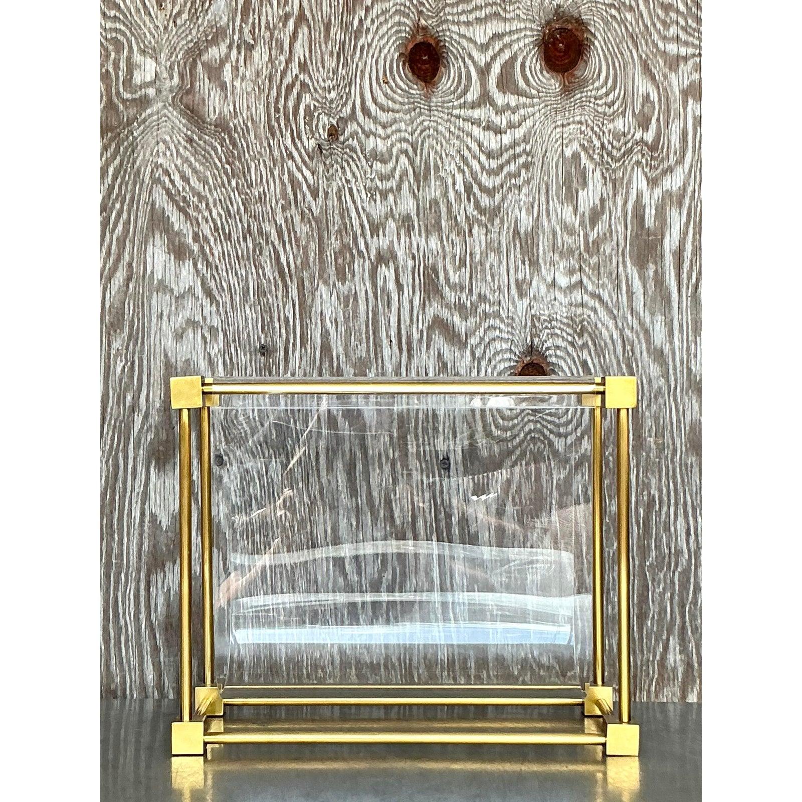 Elevate your home decor with this exquisite vintage boho brass magazine holder, inspired by the iconic designs of Charles Hollis Jones. Featuring a sleek, open-frame brass structure with clear acrylic panels, this sophisticated piece embodies the