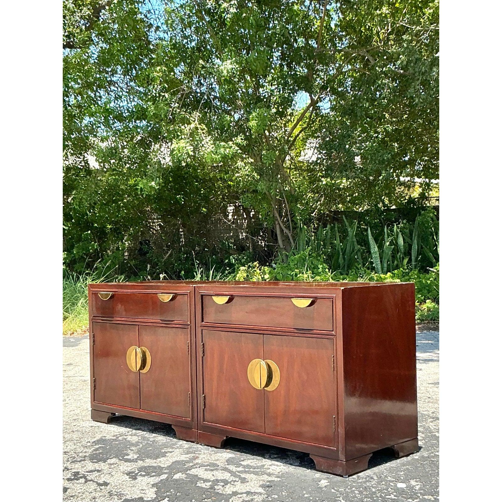 Élevez votre chambre à coucher ou votre espace de vie avec cette paire de tables de chevet à médaillon en laiton vintage, exsudant un mélange sophistiqué d'élégance du milieu du siècle et de flair chinois. Fabriqués en bois riche et foncé avec une