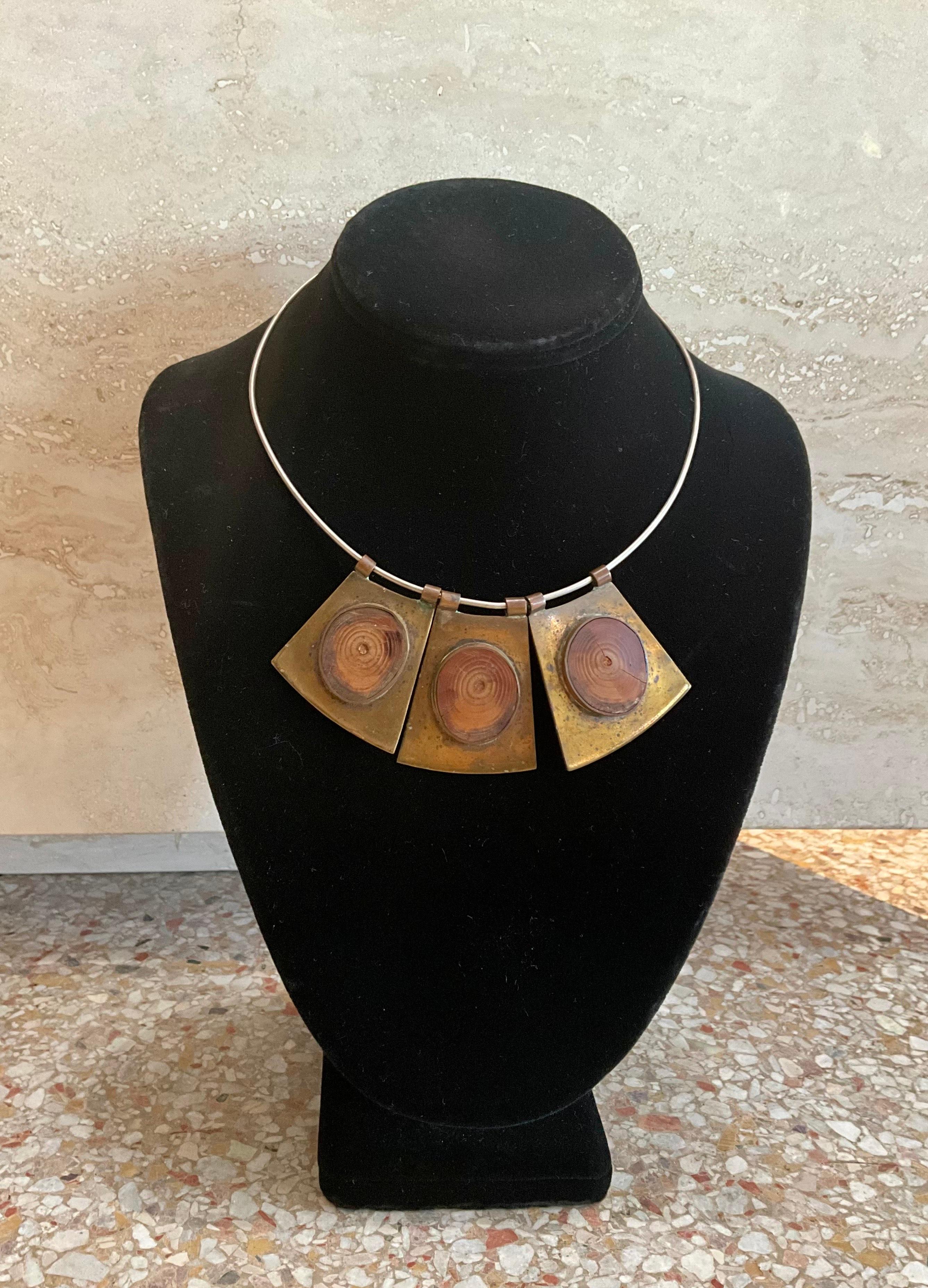 This vintage boho brass and wood bib necklace is a unique, statement-making piece of jewelry that combines natural materials with a bold, artistic design, embodying the free-spirited, eclectic vibe of bohemian fashion. This type of necklace often