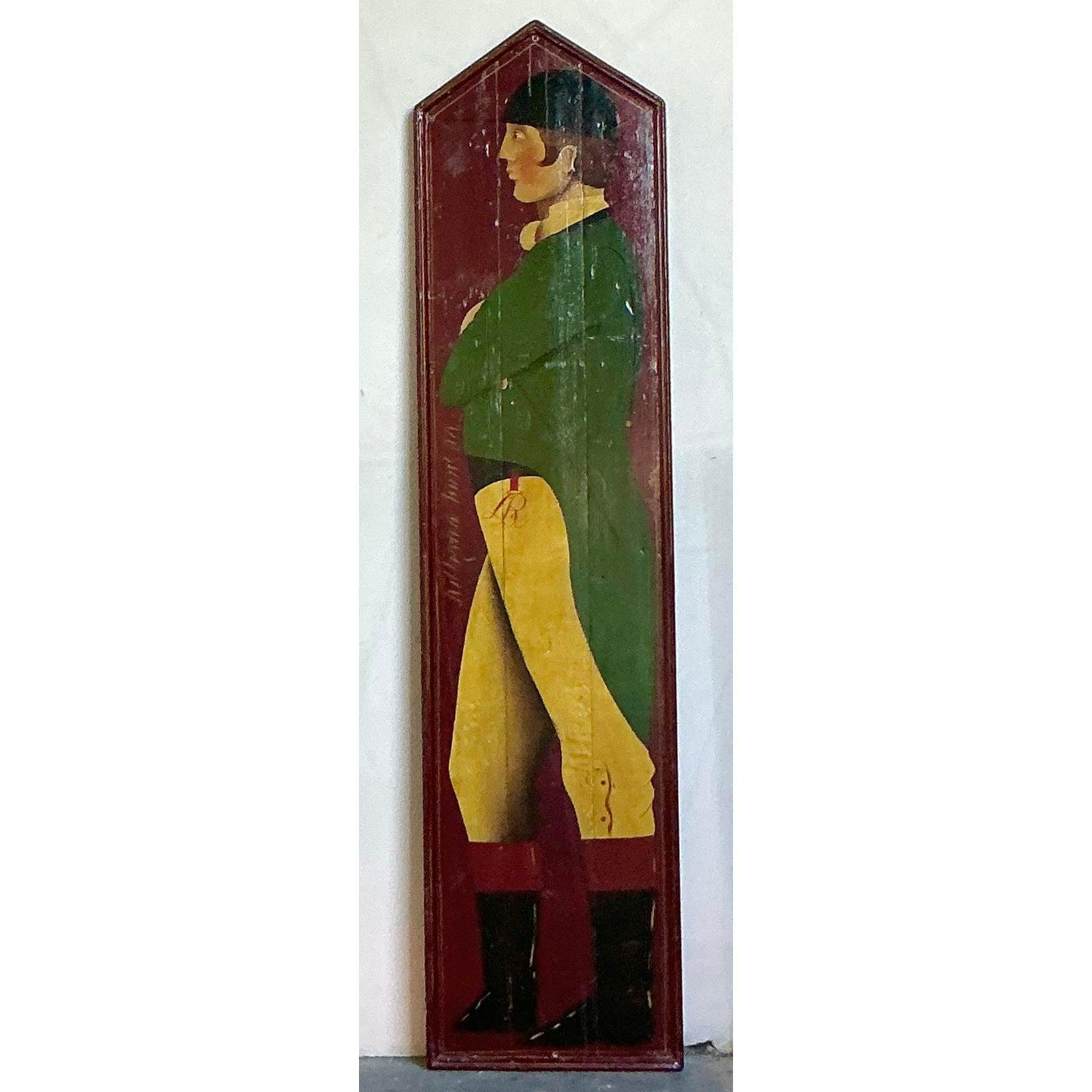Cattura il fascino senza tempo dello sport equestre classico con questo monumentale pannello da fantino vintage dipinto a mano. Realizzato in un accattivante stile folk art, questo pezzo è dipinto su un sostanzioso pannello di legno, con un fantino