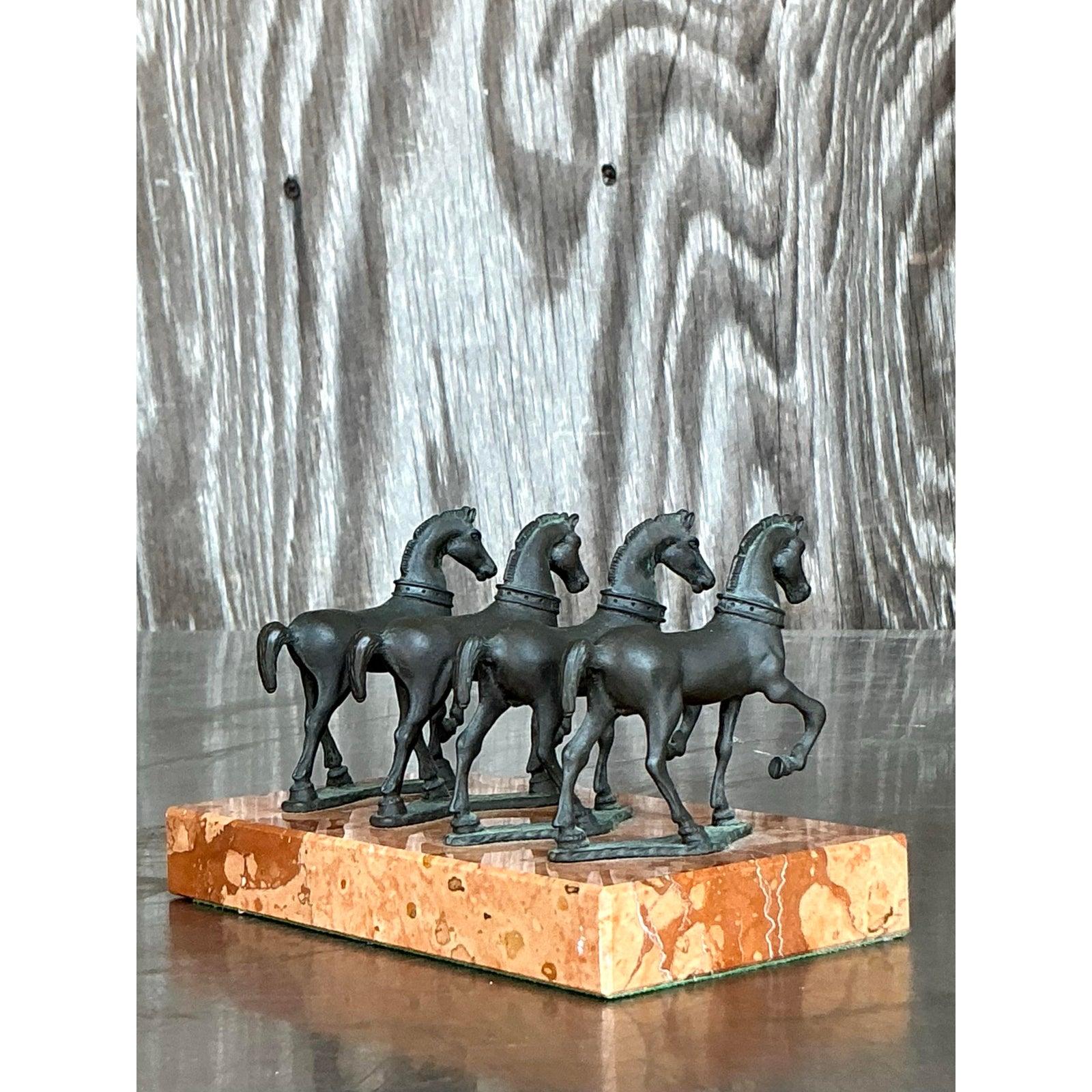 Porta movimento, eleganza e simbolismo nel tuo arredamento con questa scultura di cavallo in bronzo Vintage Boho. Caratterizzato da quattro cavalli di bronzo in bilico, questo pezzo unico poggia su una base di marmo riccamente venata, che ne esalta