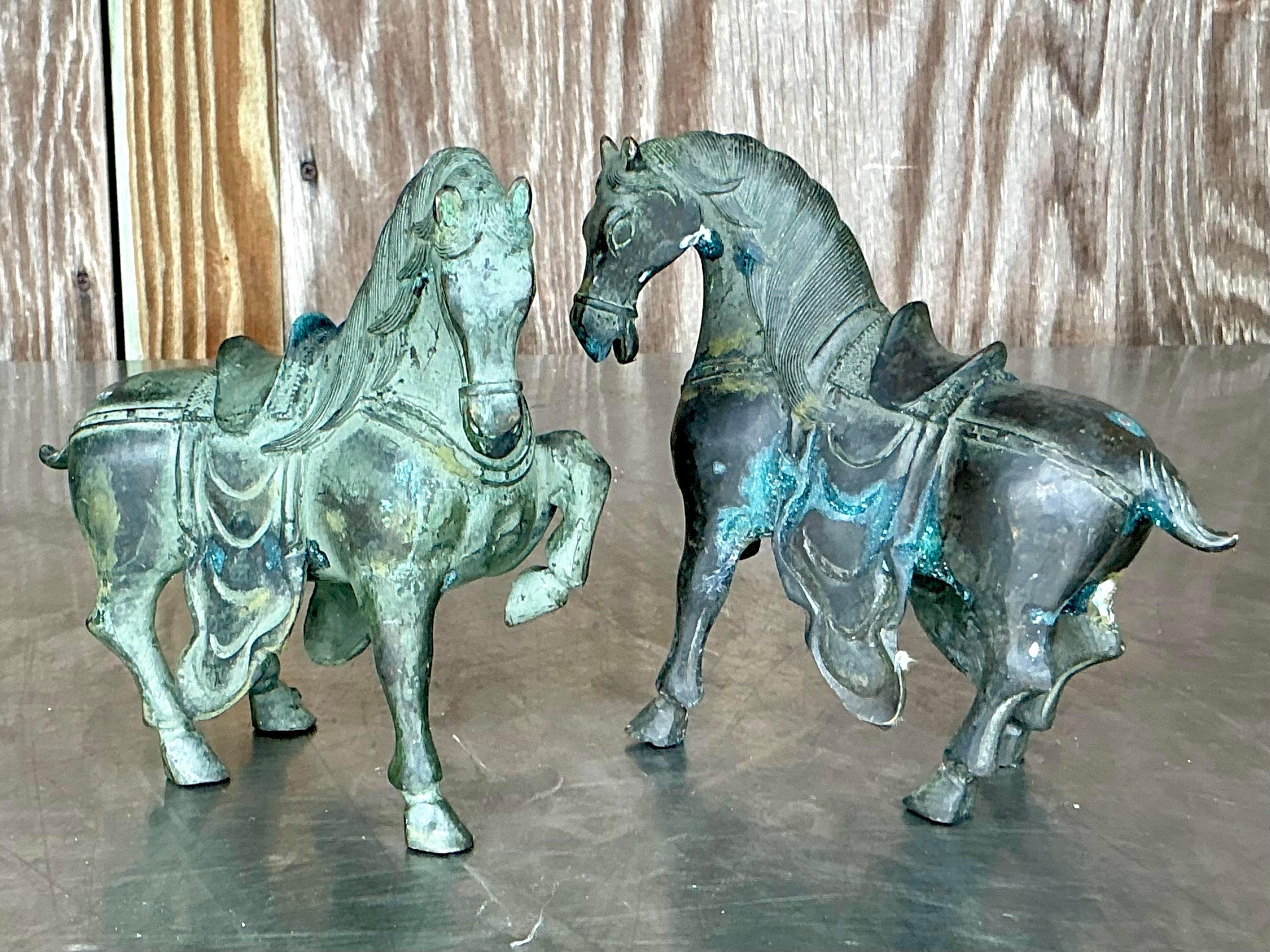 Eleva il tuo arredamento con questo affascinante set di Cavalli del Tempio vintage boho in bronzo. Ogni pezzo di questa coppia è una testimonianza di intricata maestria artigianale, con dettagli eleganti che emanano un'aura di bellezza senza tempo.