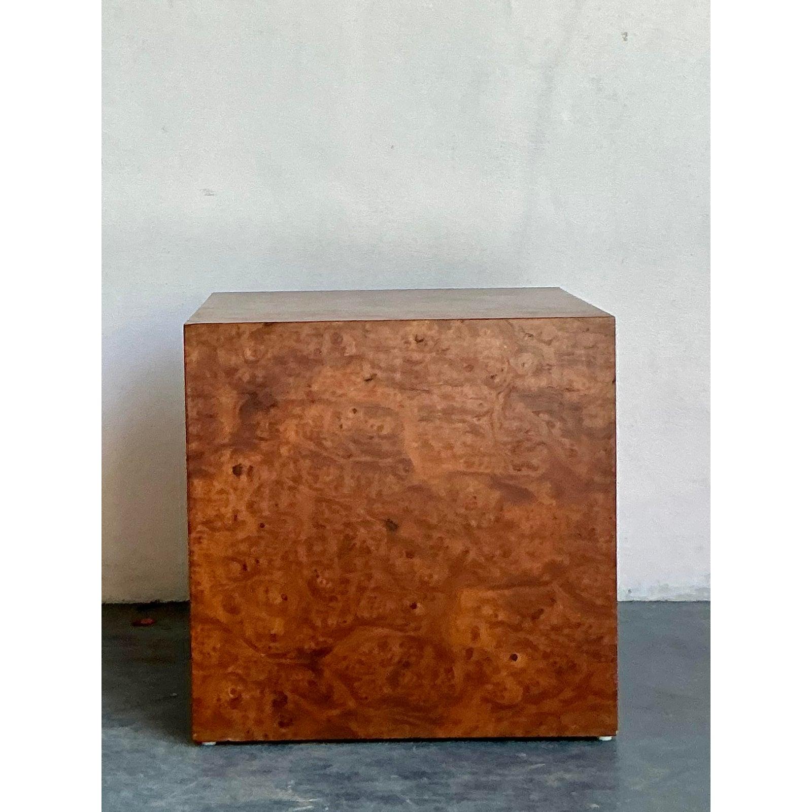 Abbraccia la bellezza pura e organica di questo squisito tavolo a cubo in legno di radica vintage. Esempio di design minimalista degli anni '70, questa solida forma a blocco funge da tela perfetta per le volute ipnotiche dell'impiallacciatura in