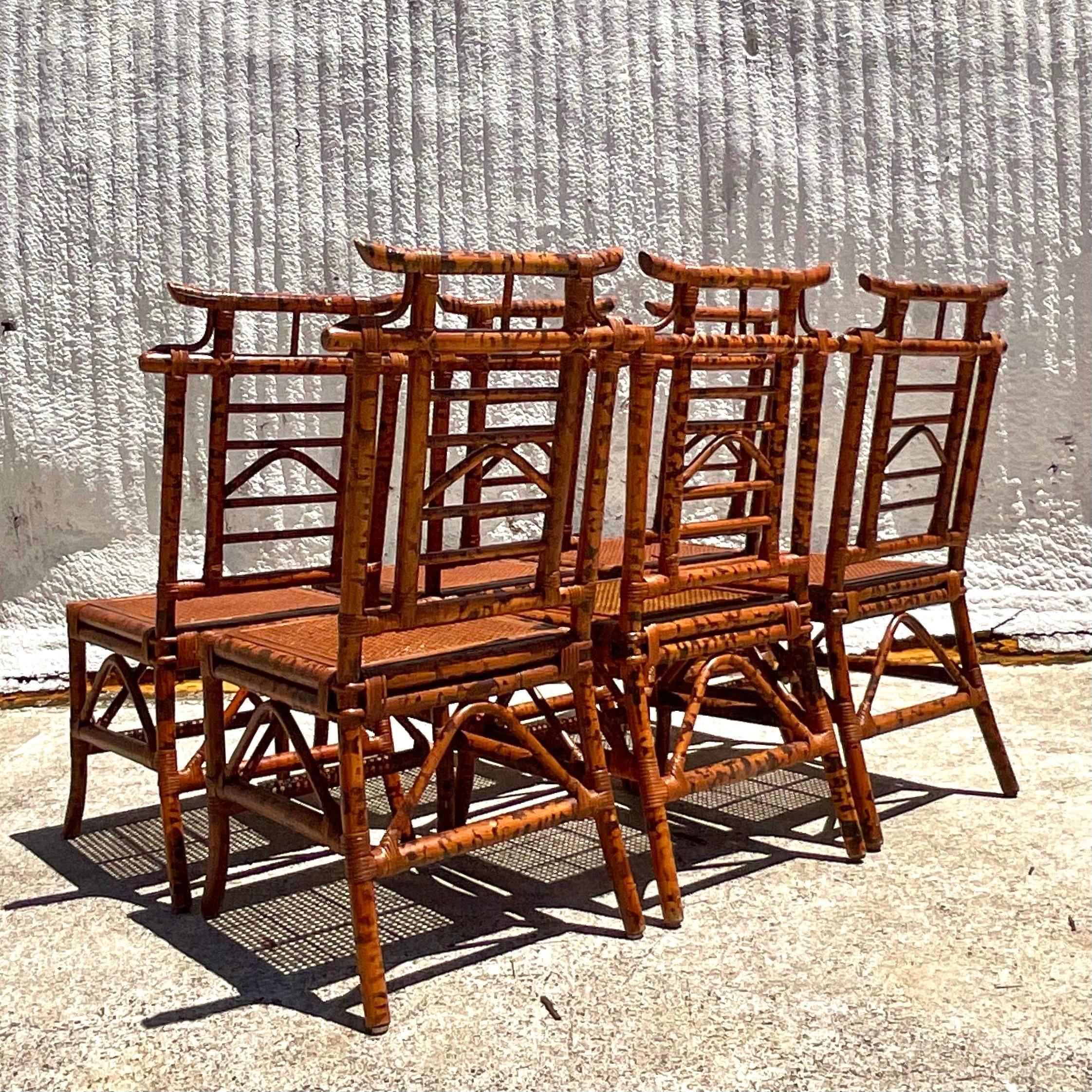 A stunning set of 6 vintage Boho dining chairs. Chic burnt bamboo pagoda frame with inset cane seat. In excellent condition. Acquired from a Palm Beach estate