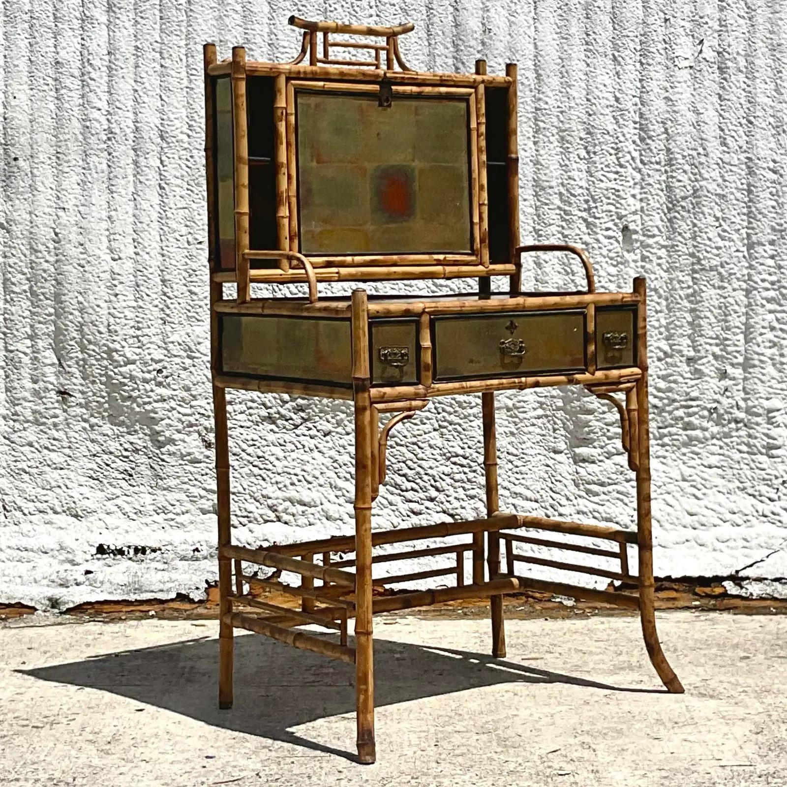 An incredible vintage Boho writing desk. Crafted in a chic burnt bamboo with Chinoiserie and gilt detail. Flip down top reveals private storage. Matching burnt bamboo pagoda chair with inset cane seat. Acquired from a Palm Beach estate.