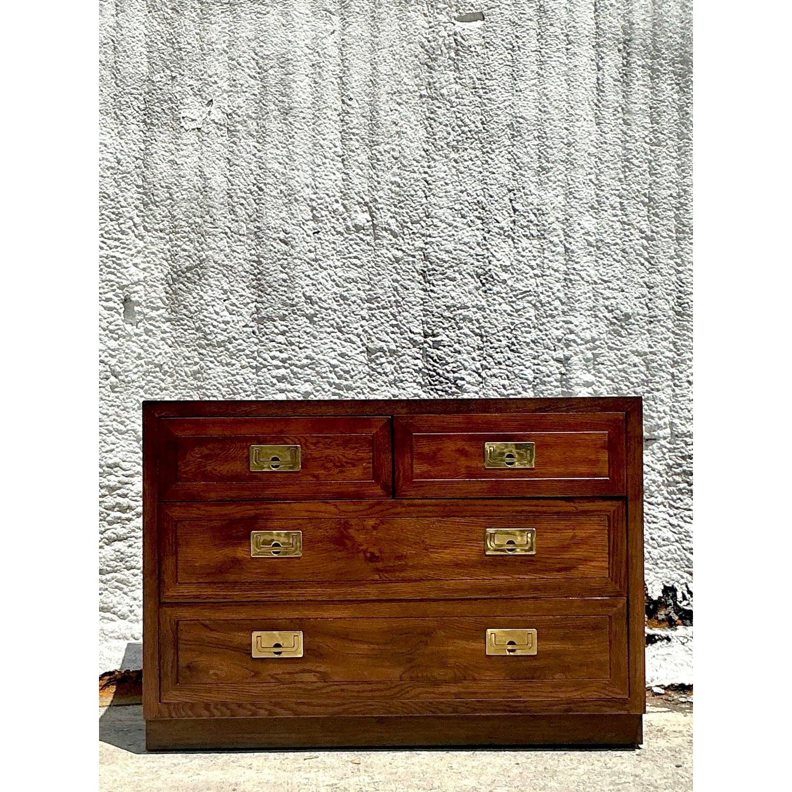 Infuse your interior with enduring style using this classic vintage Campaign chest of drawers. Showcasing the signature recessed brass pulls synonymous with Campaign furniture, this piece offers both timeless appeal and practical storage. The clean