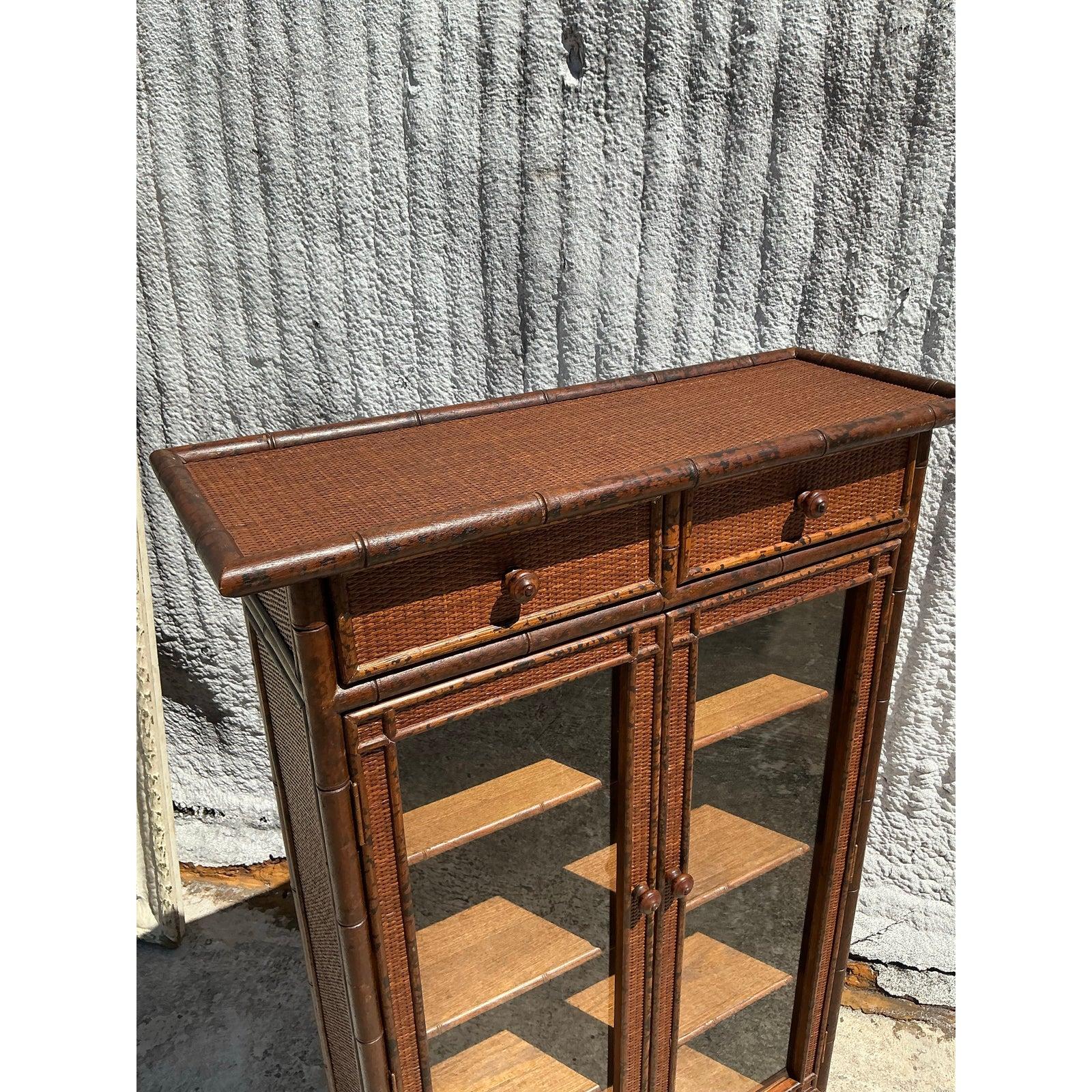 Bring an air of natural elegance to your space with this stunning vintage carved bamboo cabinet. Featuring a rich woven rattan frame, mirrored glass doors, and two convenient storage drawers, this piece is both functional and visually captivating.